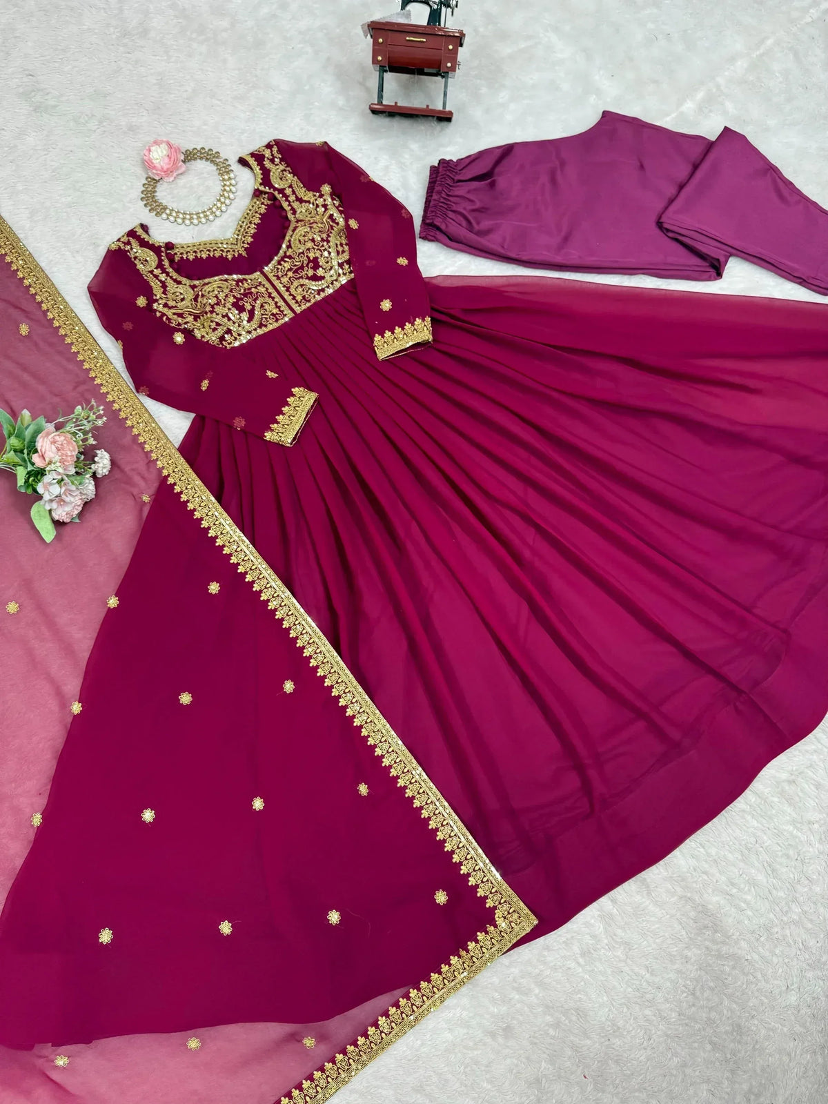 Maroon ethnic gown with gold embroidery, matching pants and dupatta, perfect for Indian celebrations