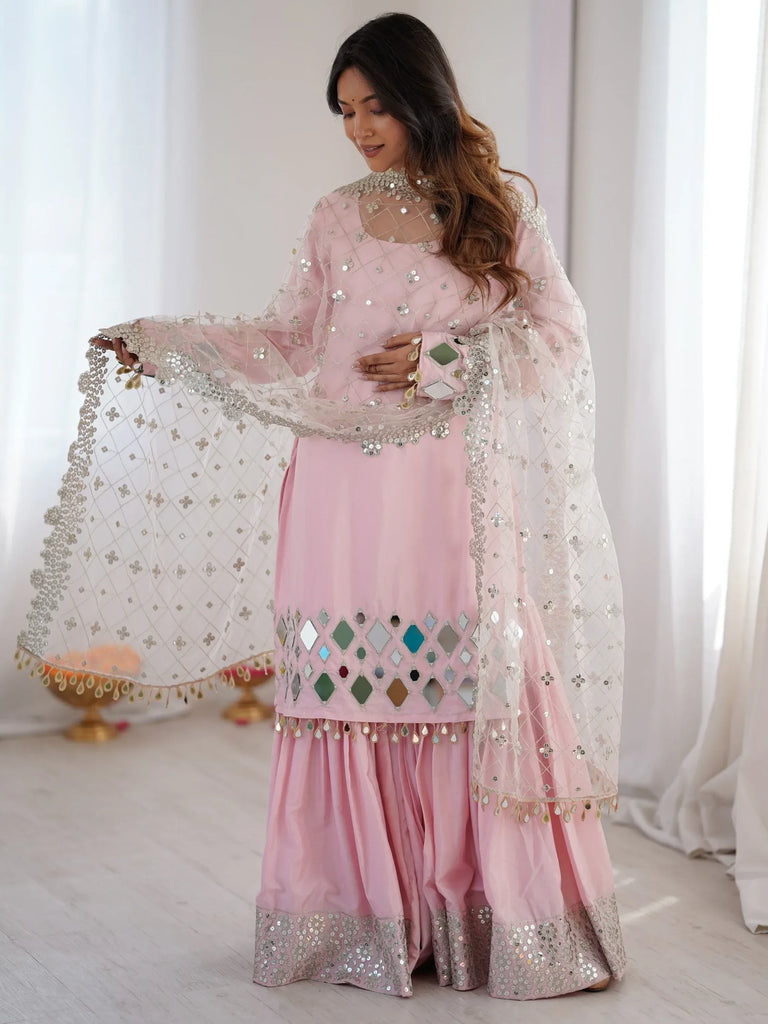 Woman wearing a pink mirror work salwar kameez with a matching embroidered dupatta