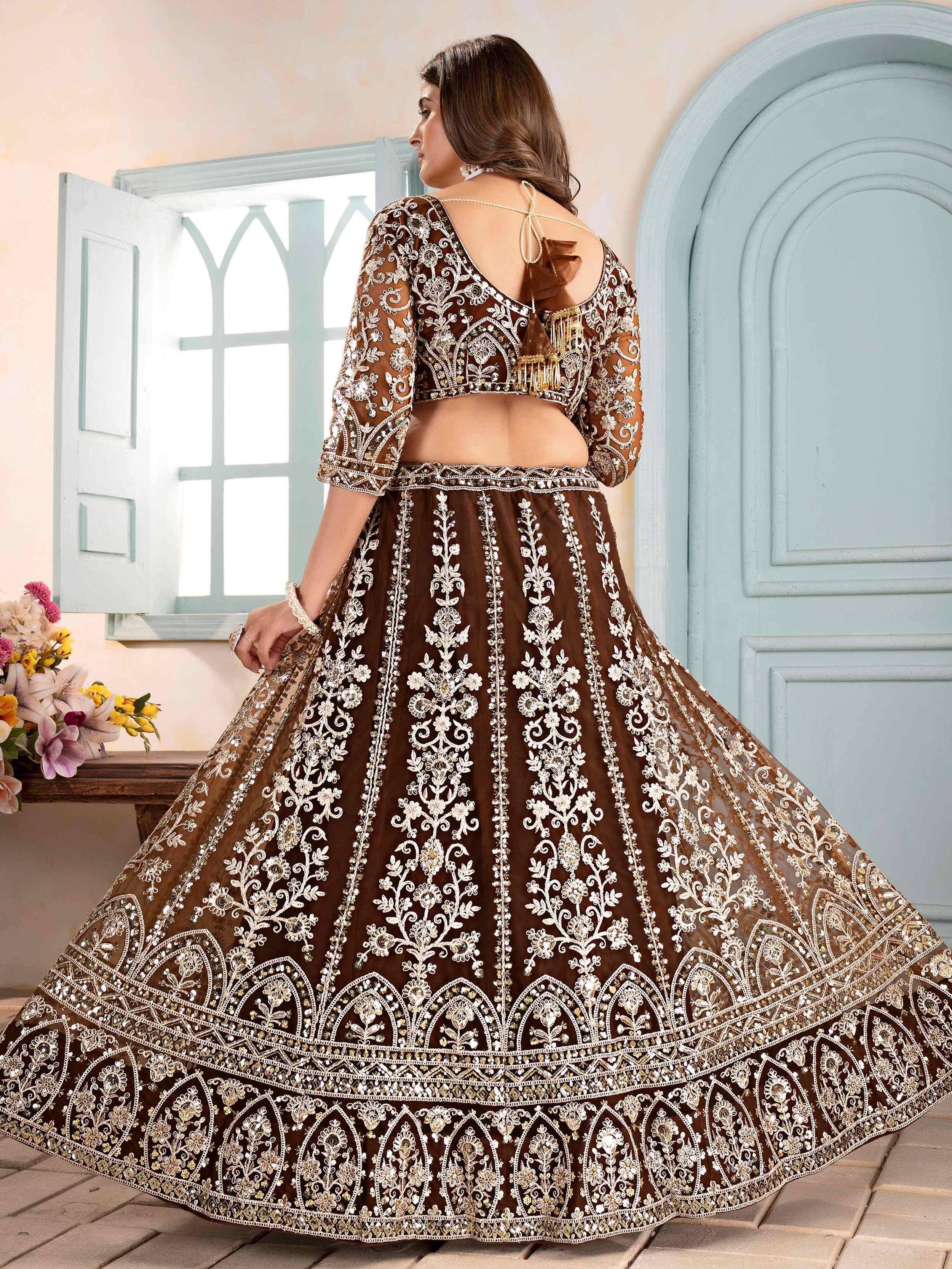Brown embroidered lehenga choli with floral zari work, back view near blue window