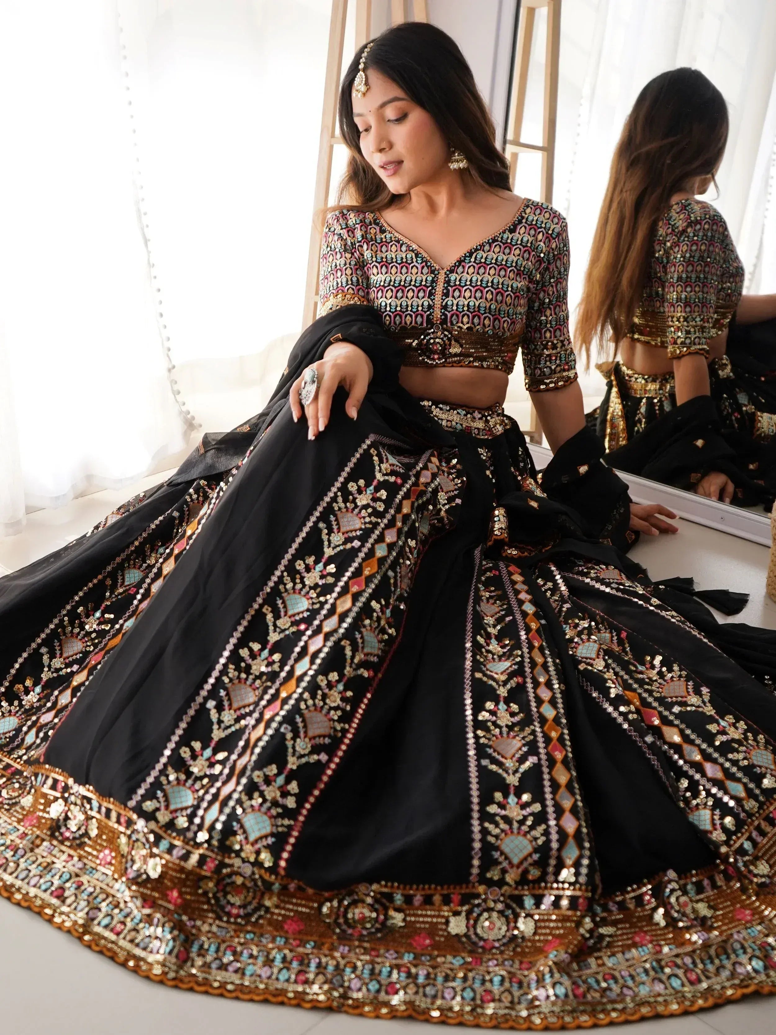 Black embroidered lehenga choli with colorful mirror work, perfect for Indian ethnic wear and festive occasions.