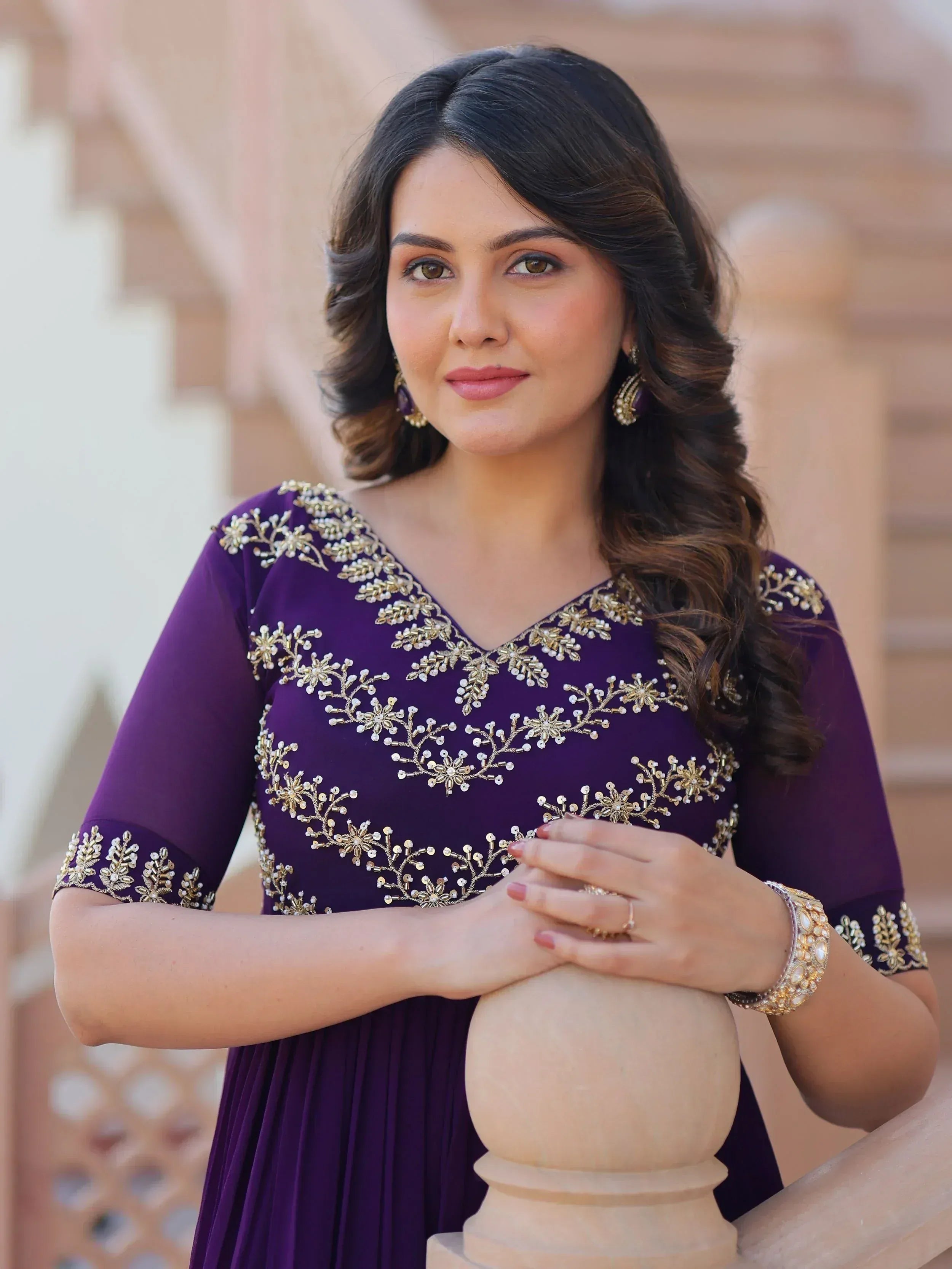 Woman in purple ethnic gown with gold embroidery, perfect for Indian occasions