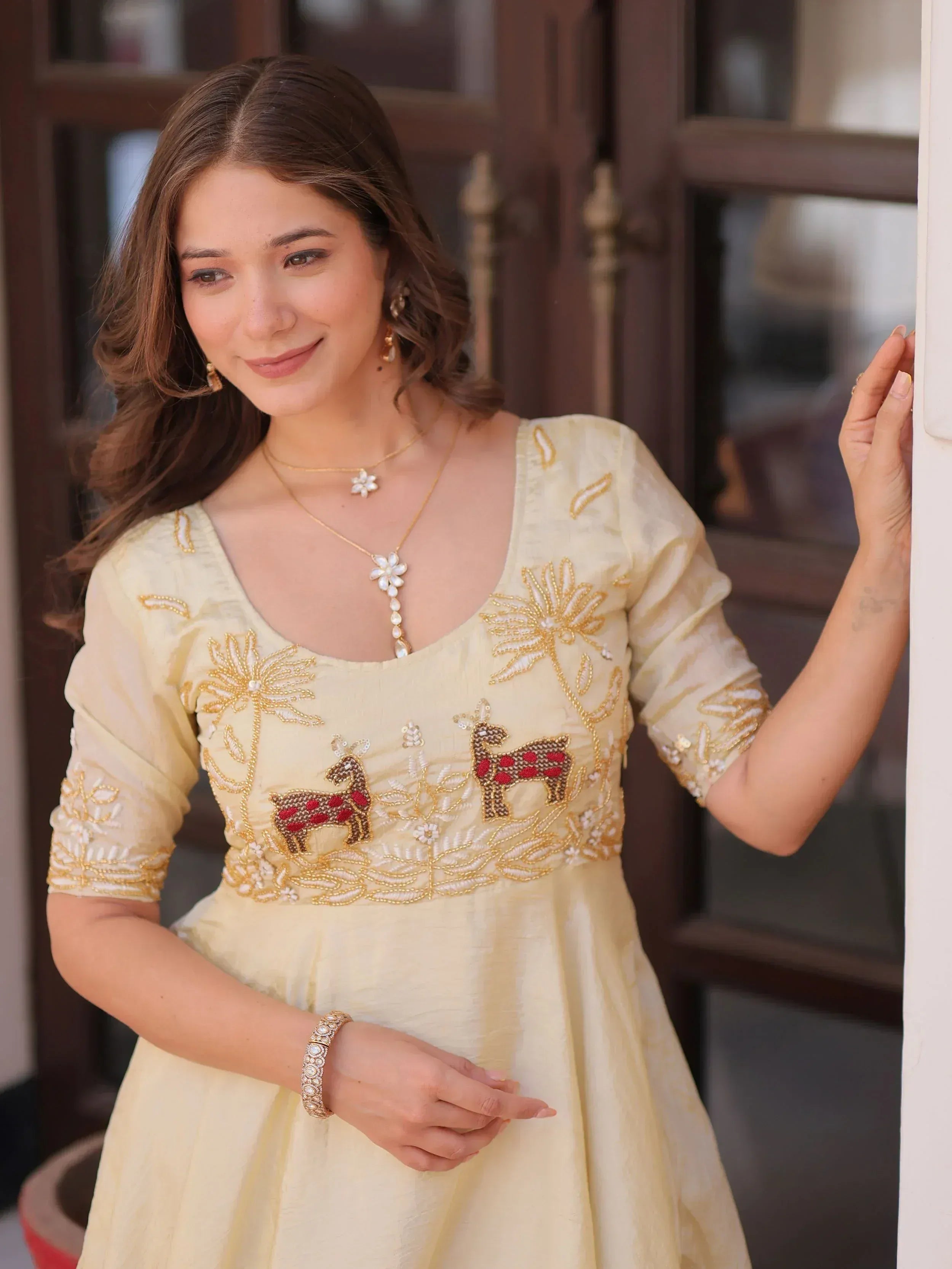 Yellow ethnic gown with deer and floral embroidery, perfect for Indian occasions