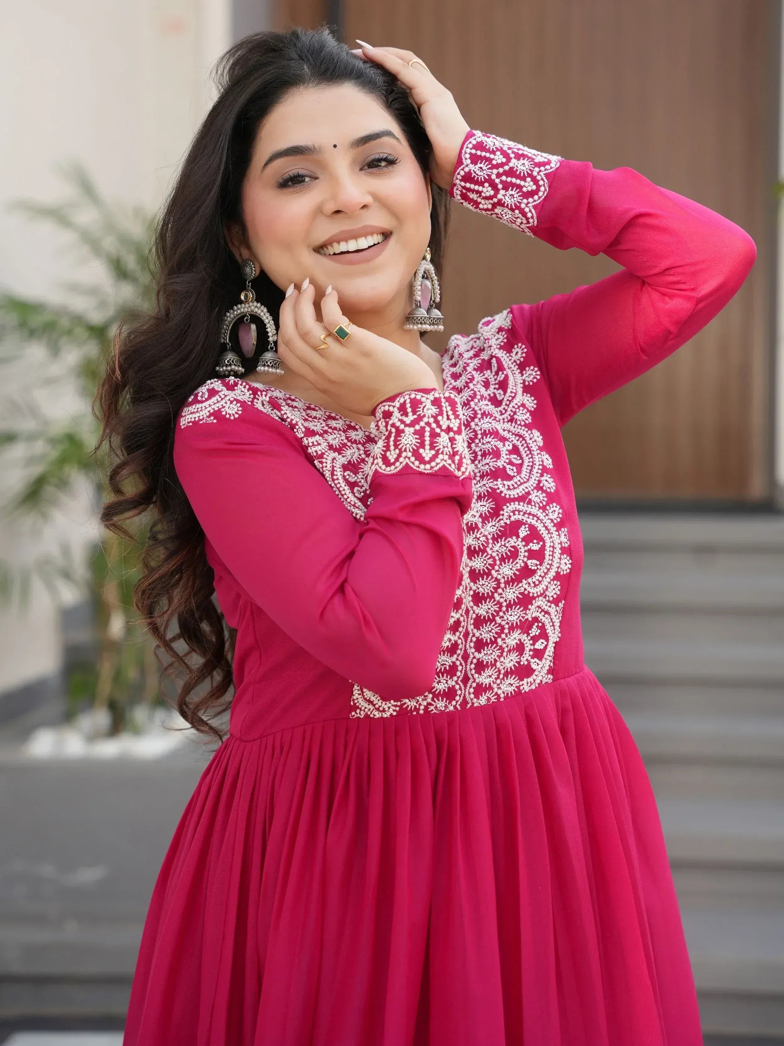 Woman in pink ethnic gown with white embroidery, perfect for Indian occasions and festive wear.