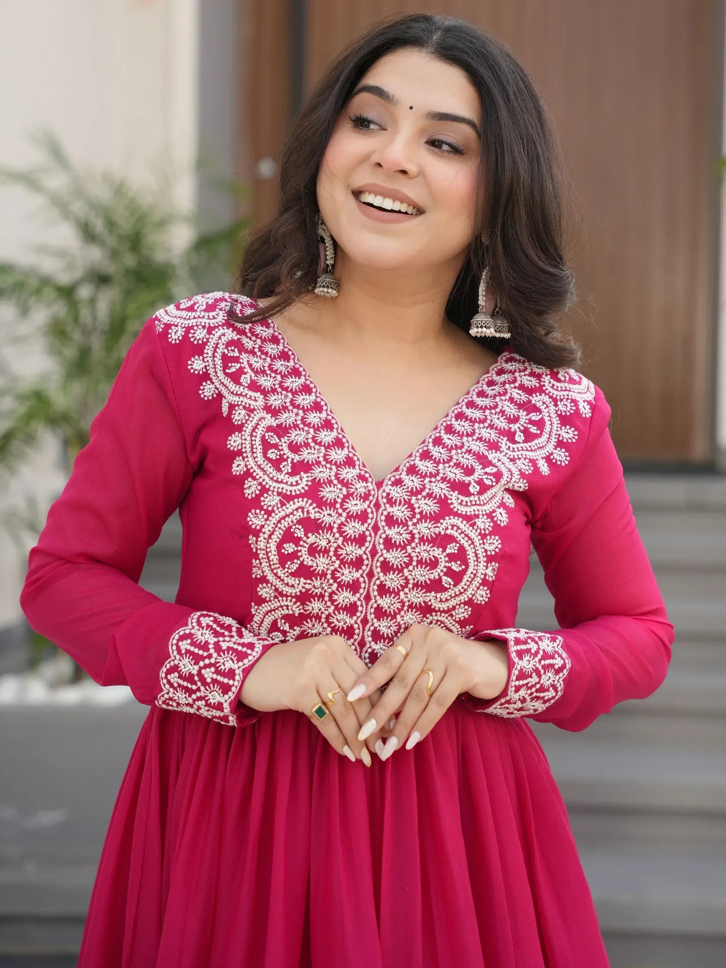 Woman in pink ethnic gown with white embroidery, perfect for Indian occasions and festive wear.