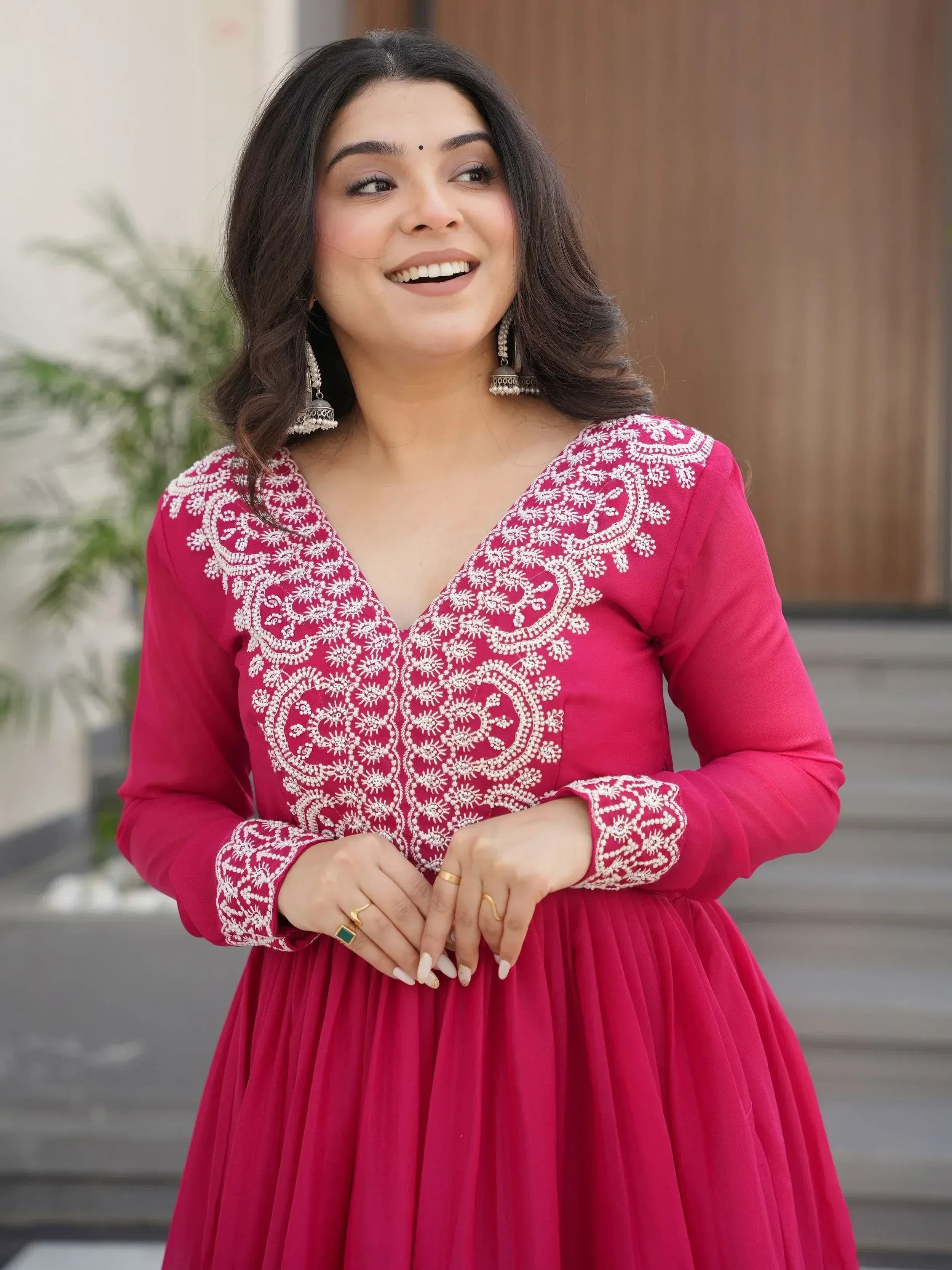Woman in pink embroidered ethnic gown with white detailing, perfect for Indian occasions and festive wear.