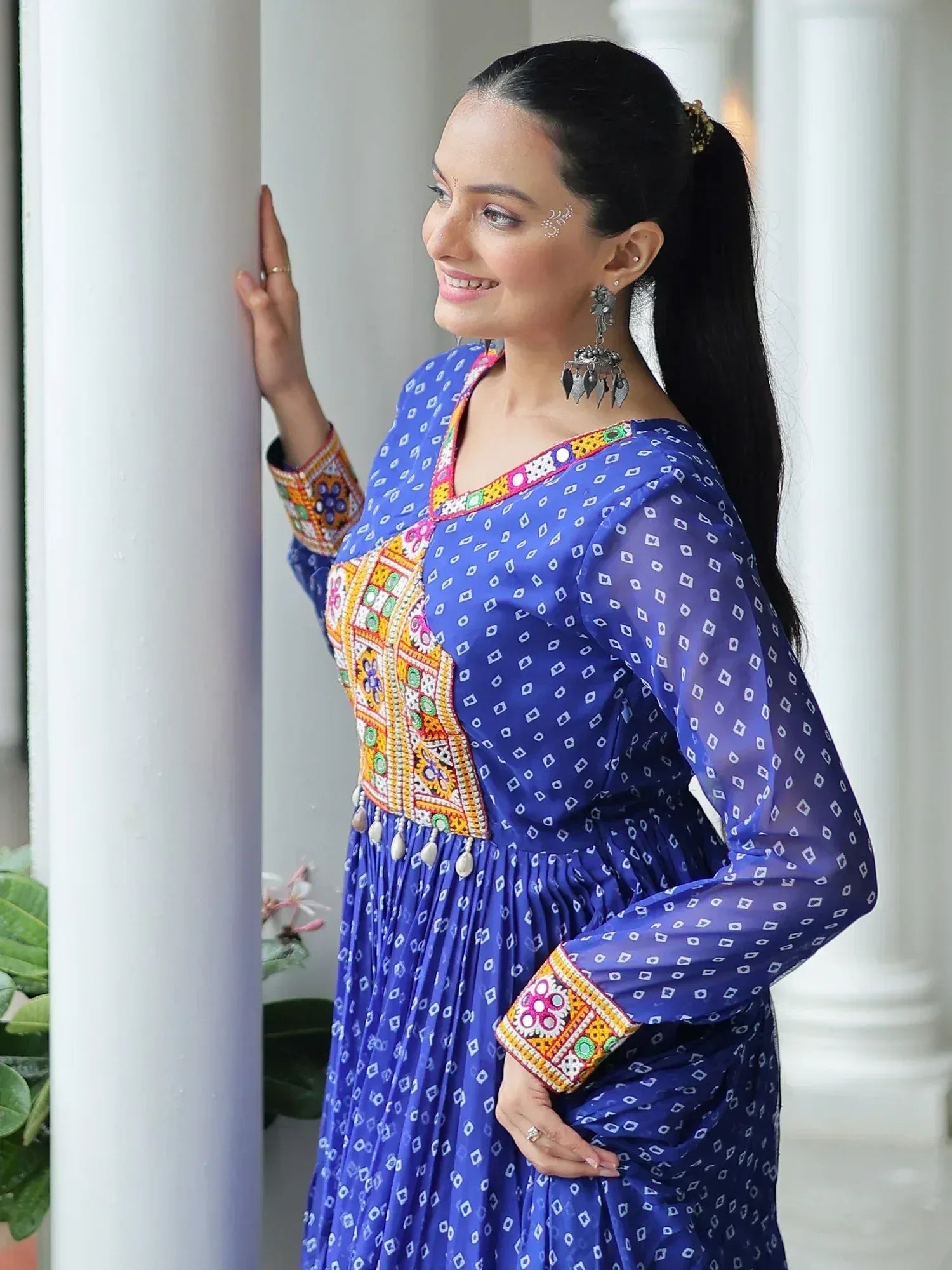 Woman in blue embroidered ethnic gown with mirror work, perfect for Indian festive occasions