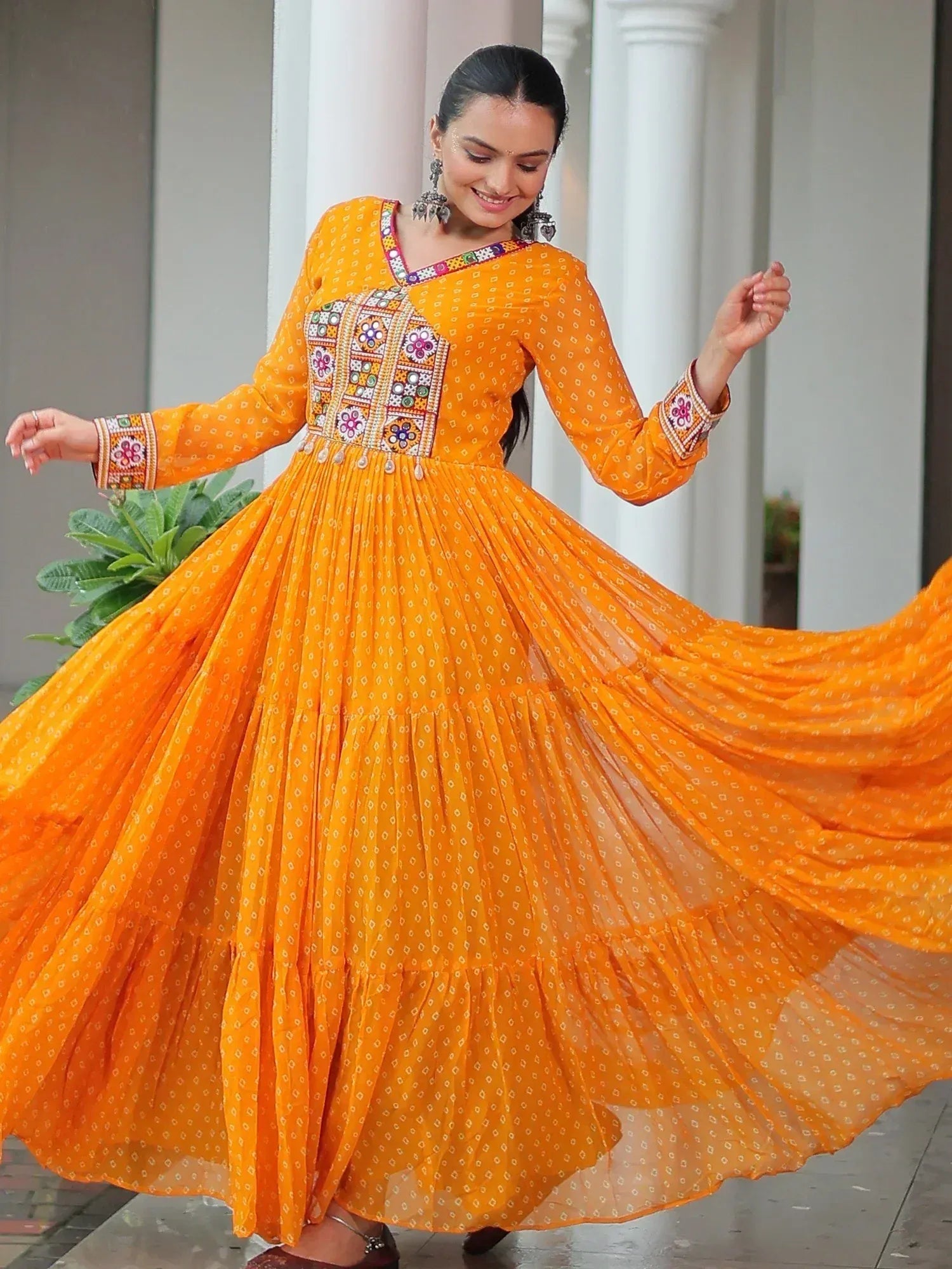 Vibrant orange ethnic gown with floral embroidery, perfect for Indian festivals and occasions