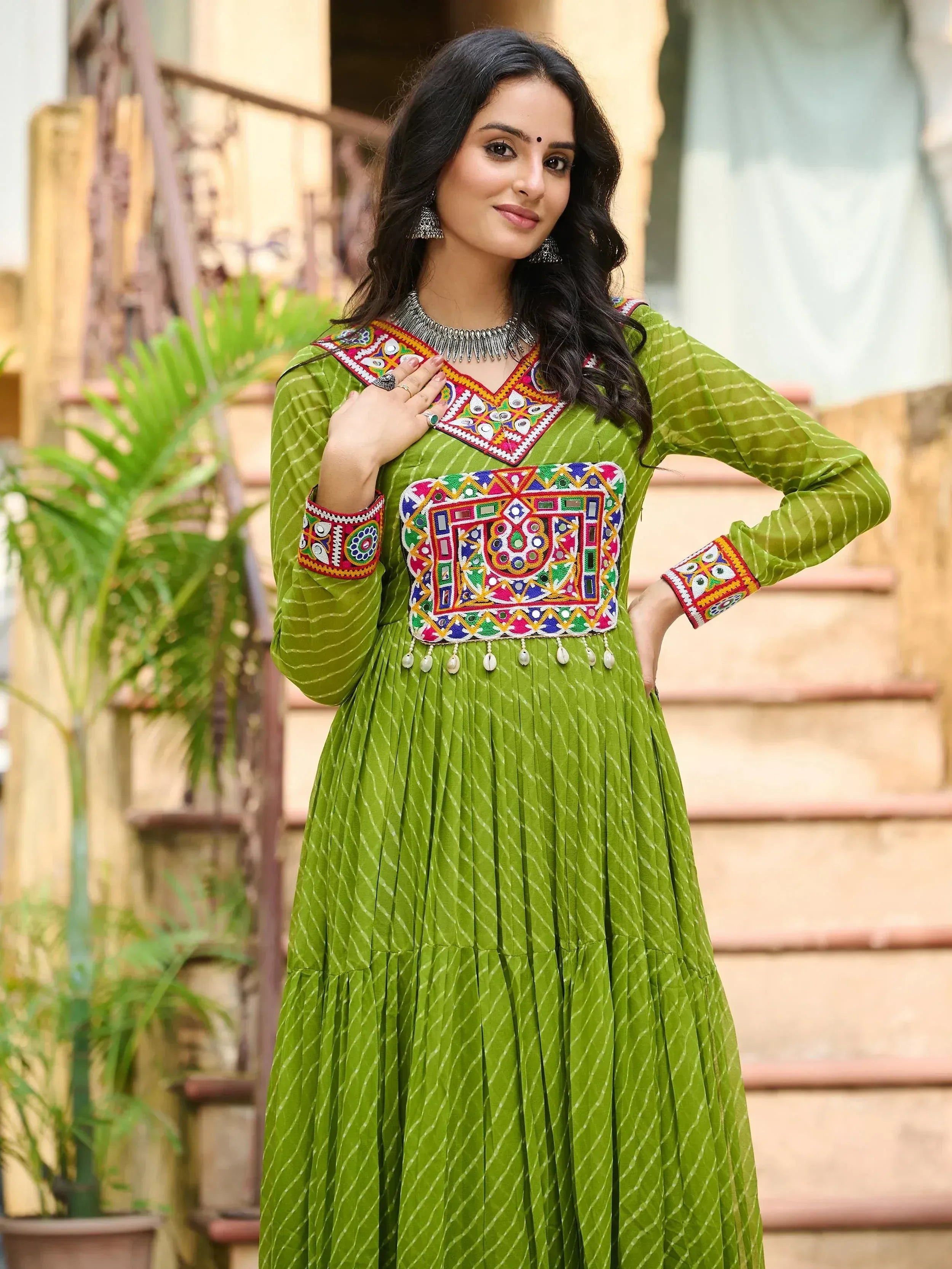 Green ethnic gown with mirror work and embroidery, perfect for Indian occasions