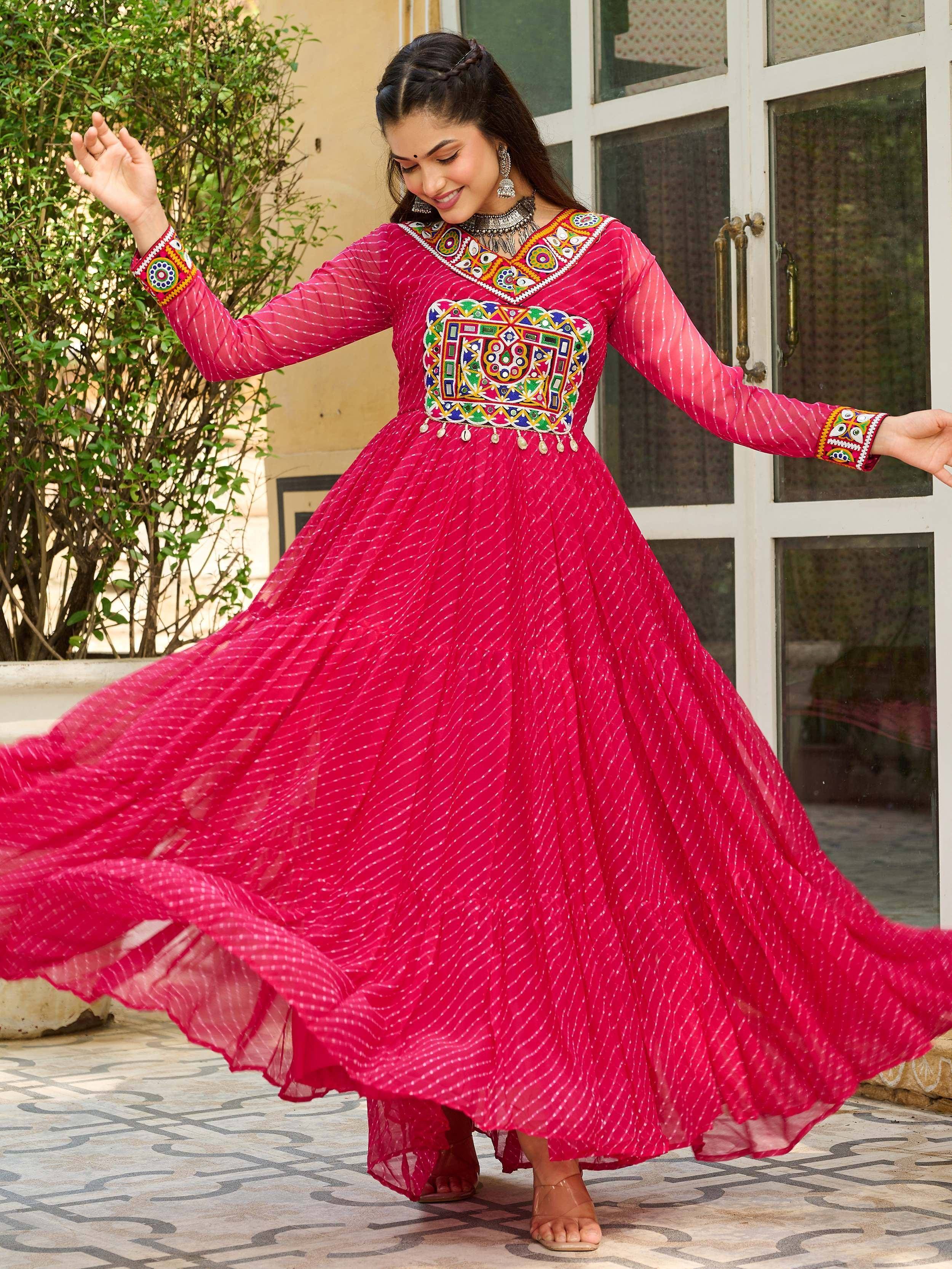 Vibrant pink ethnic gown with colorful mirror work, perfect for Indian celebrations and festive occasions.
