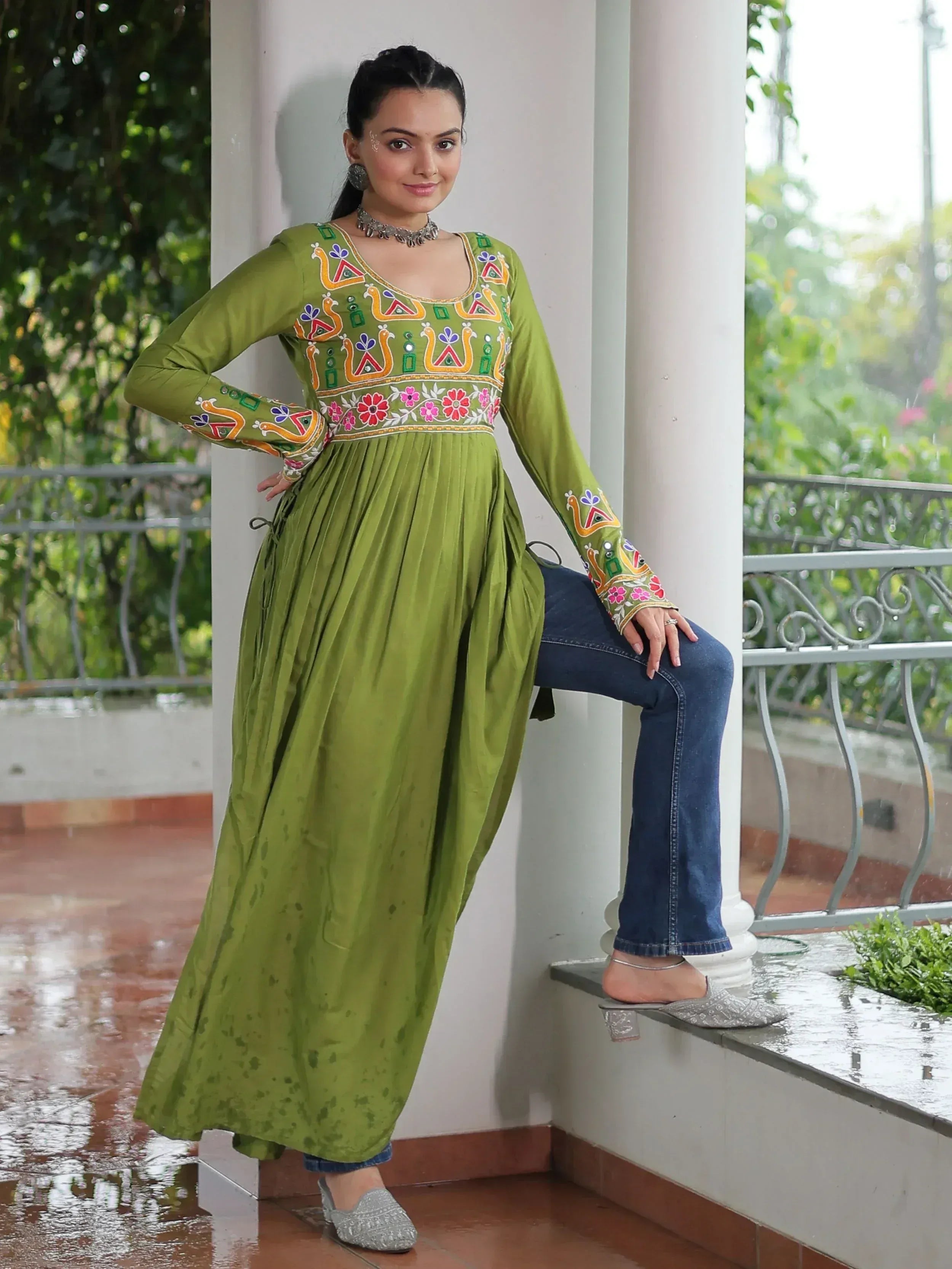Green embroidered ethnic kurta with floral and peacock motifs, paired with jeans for a fusion look