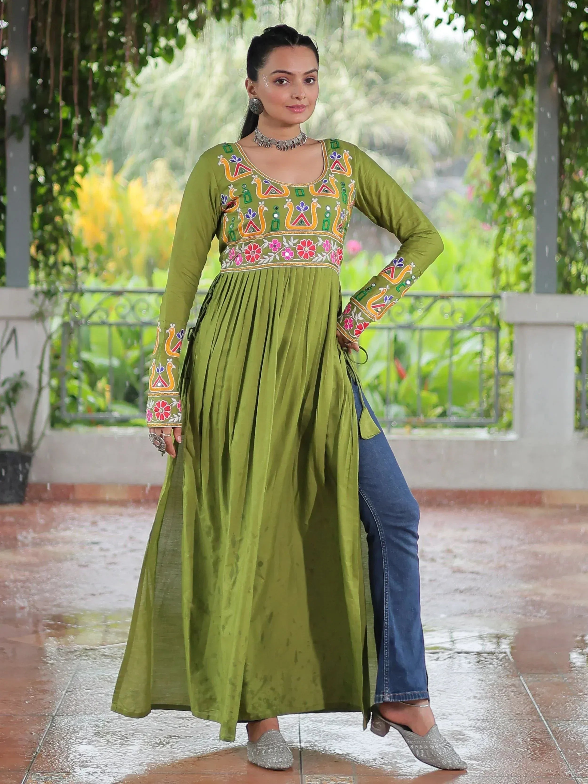 Olive green embroidered ethnic kurta with floral and peacock motifs, paired with jeans for a fusion look