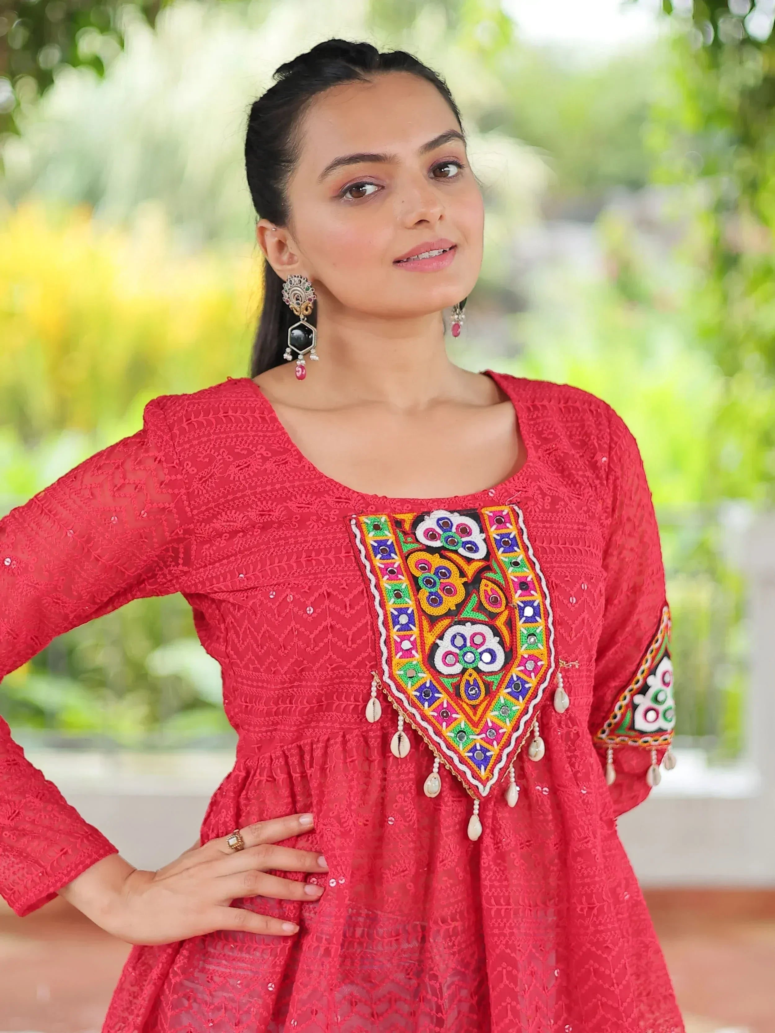 Red embroidered ethnic kurti with colorful mirror work and tassels, perfect for festive occasions.