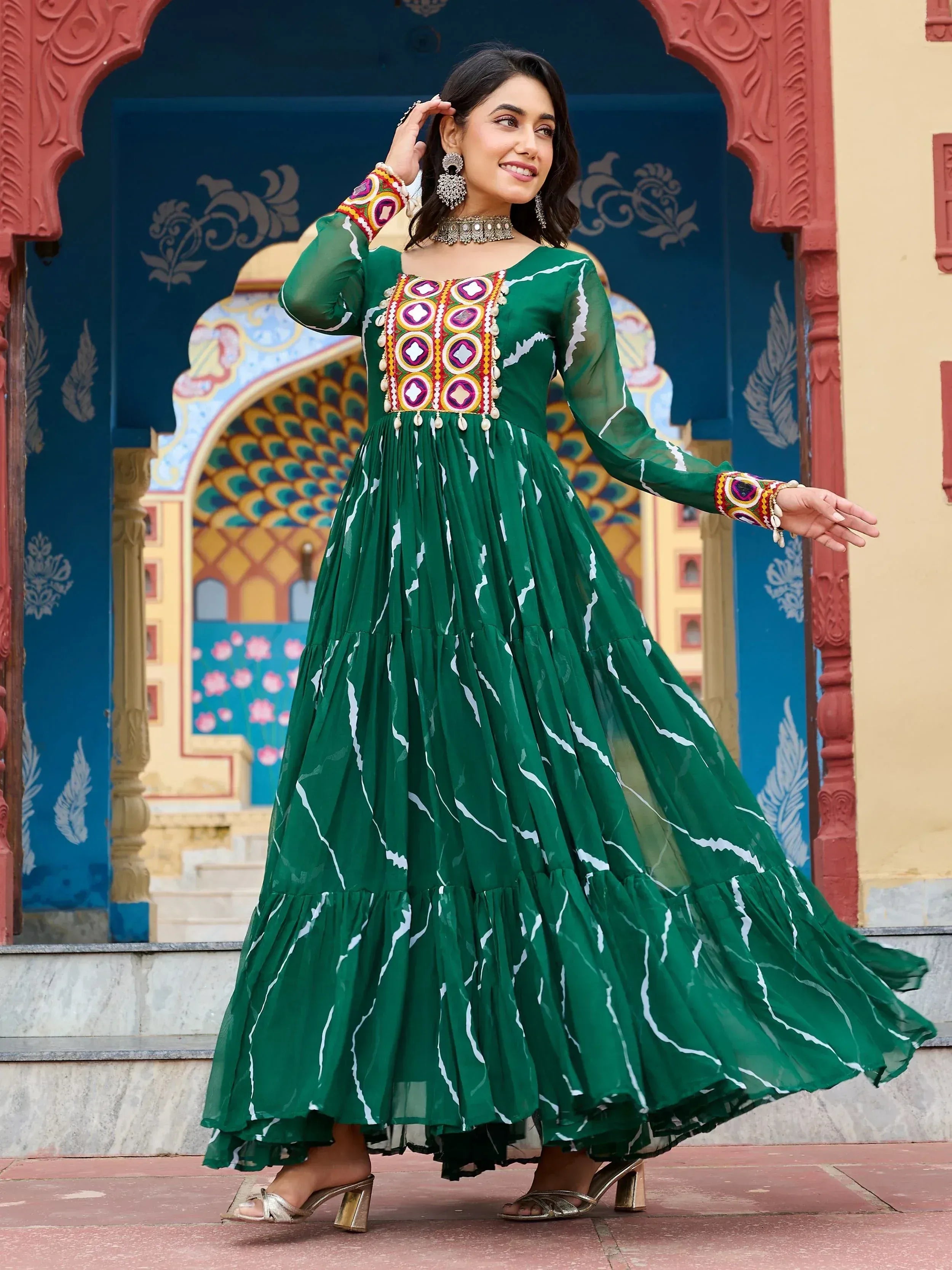 Green ethnic gown with mirror work and tiered skirt, perfect for Indian occasions