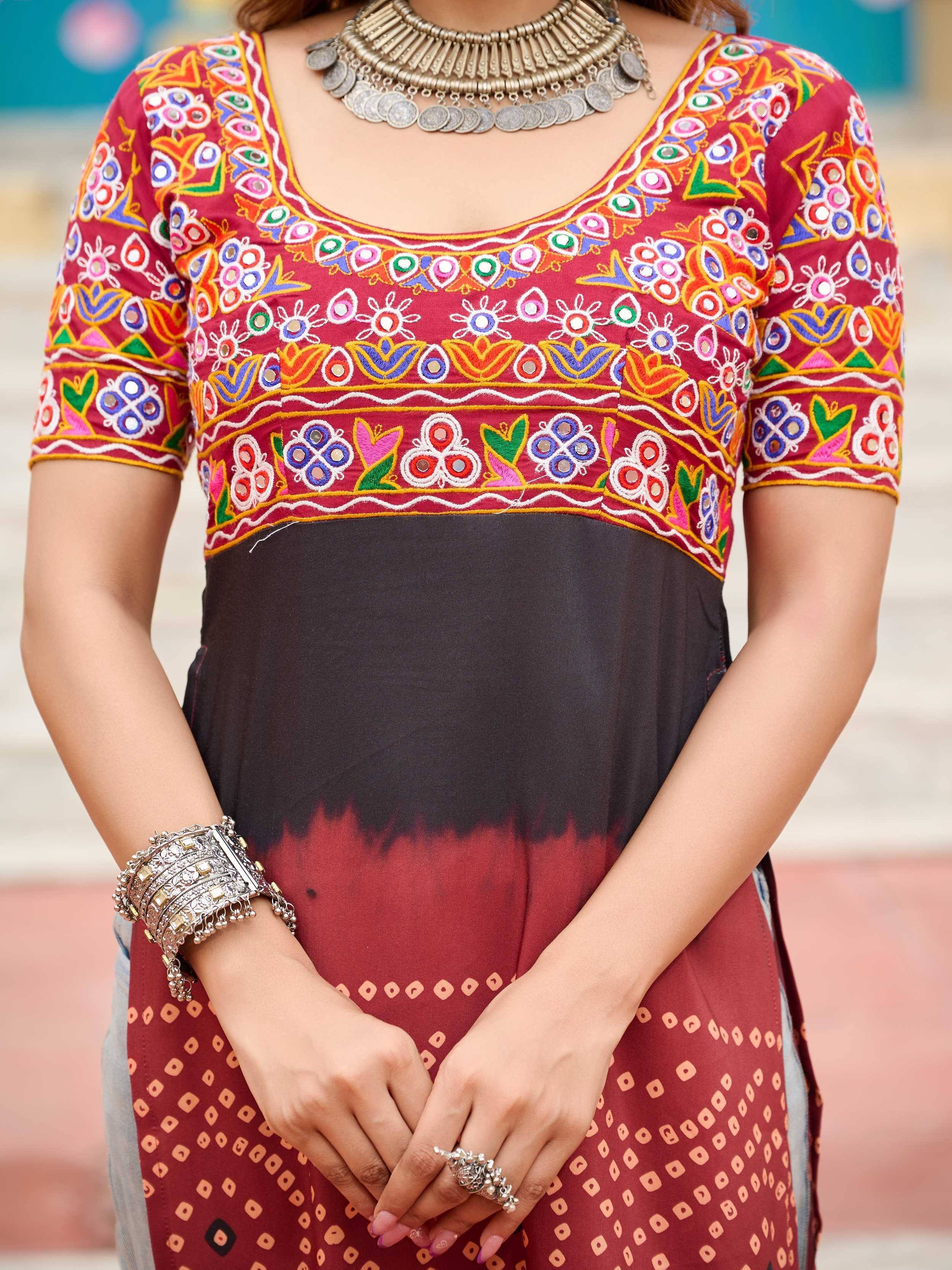 Vibrant embroidered ethnic kurti with mirror work, paired with black and red skirt, traditional jewelry