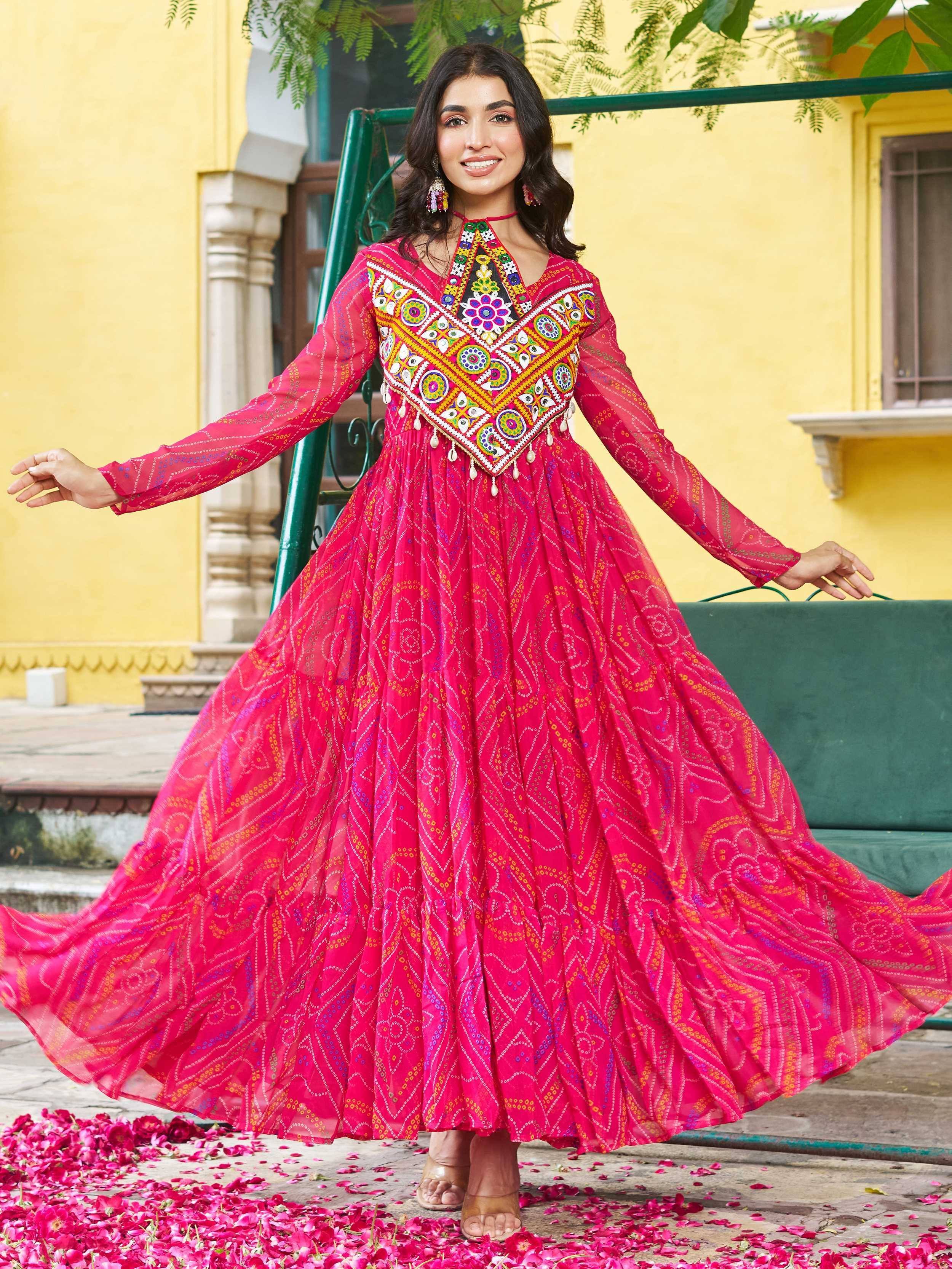 Vibrant pink ethnic gown with colorful mirror work and floral embroidery, perfect for Indian festivals and celebrations.
