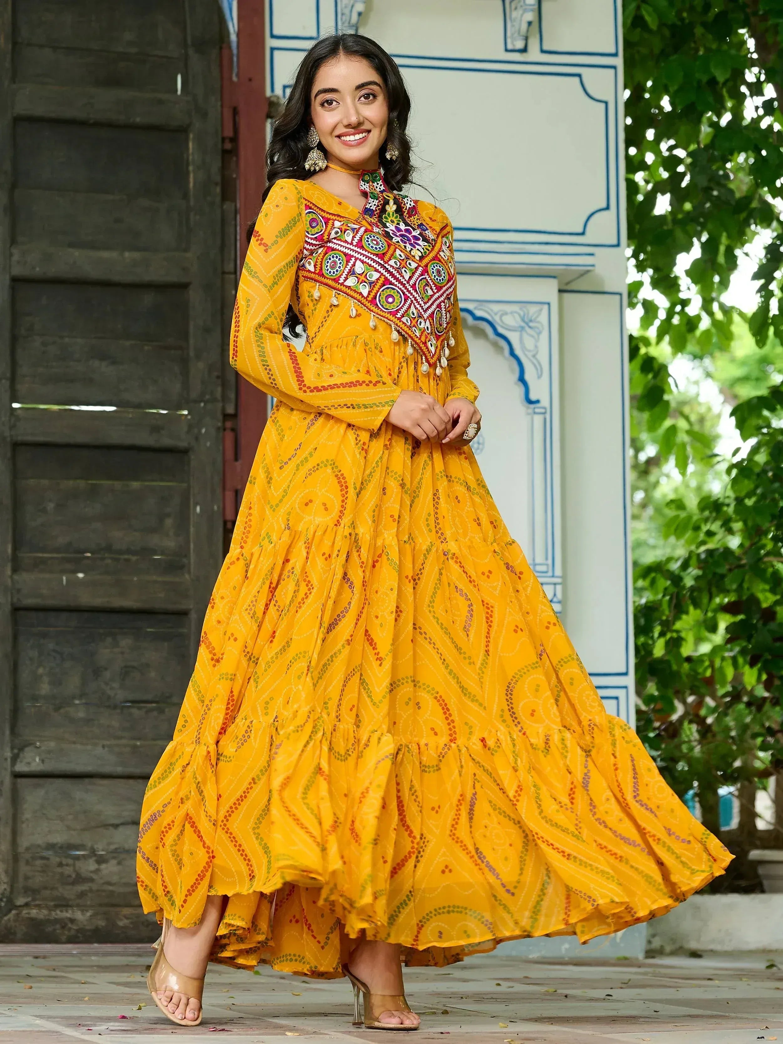 Yellow embroidered ethnic gown with mirror work, perfect for Indian festive occasions and celebrations.