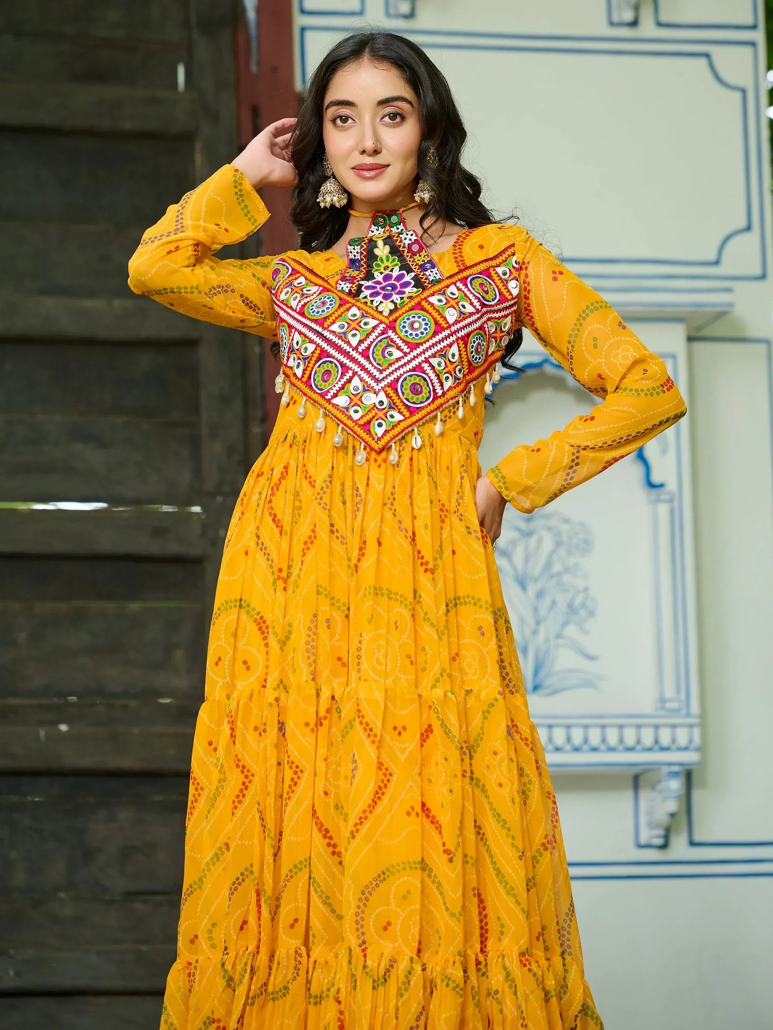 Yellow ethnic gown with colorful mirror work and embroidery, perfect for Indian festive wear