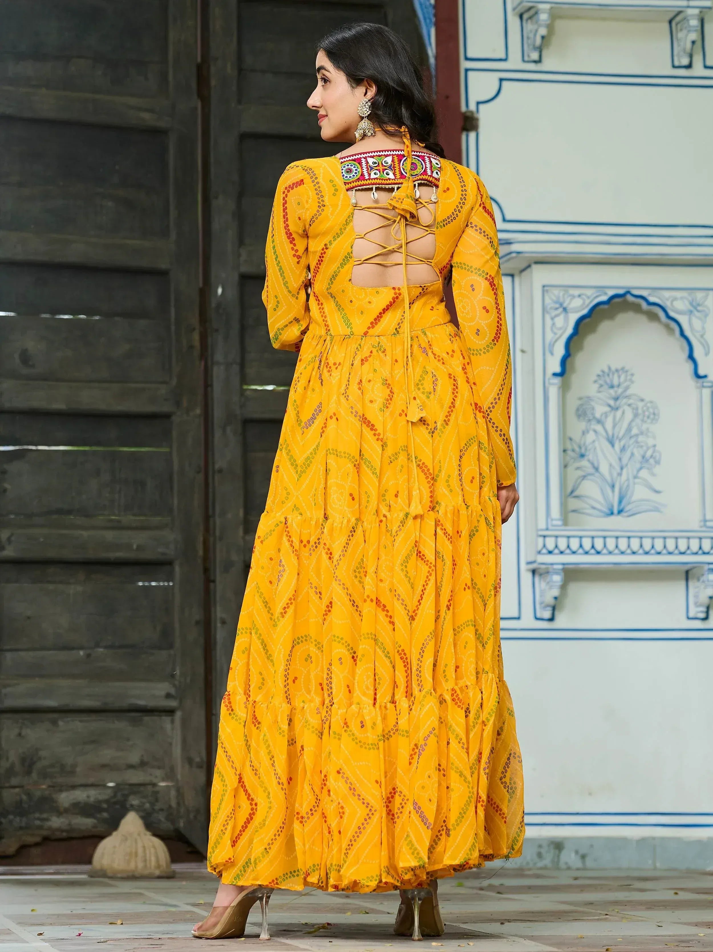 Yellow ethnic gown with mirror work and back tie detail, perfect for Indian occasions