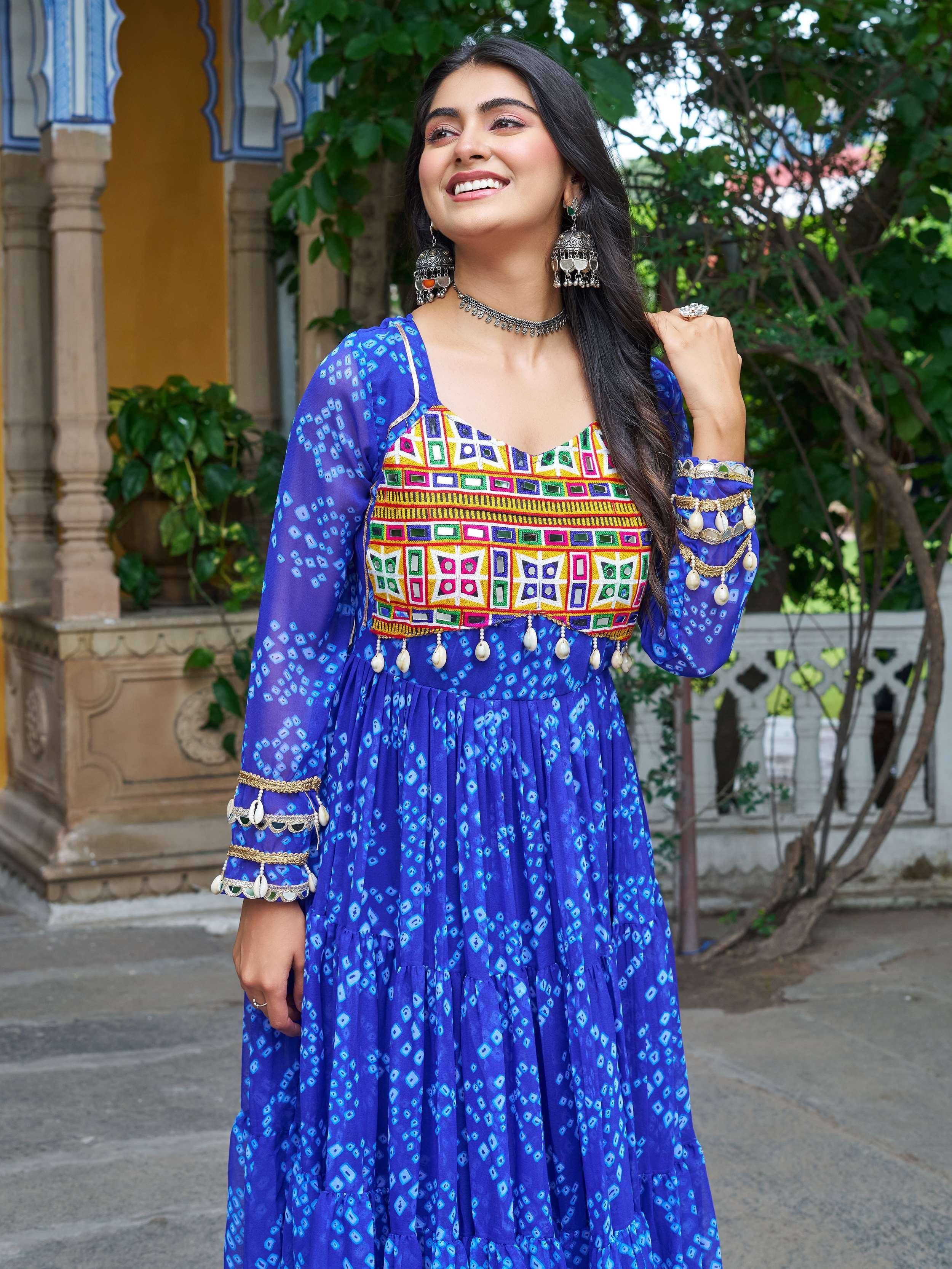 Woman in vibrant blue ethnic gown with mirror work and shell embellishments, perfect for Indian festivals
