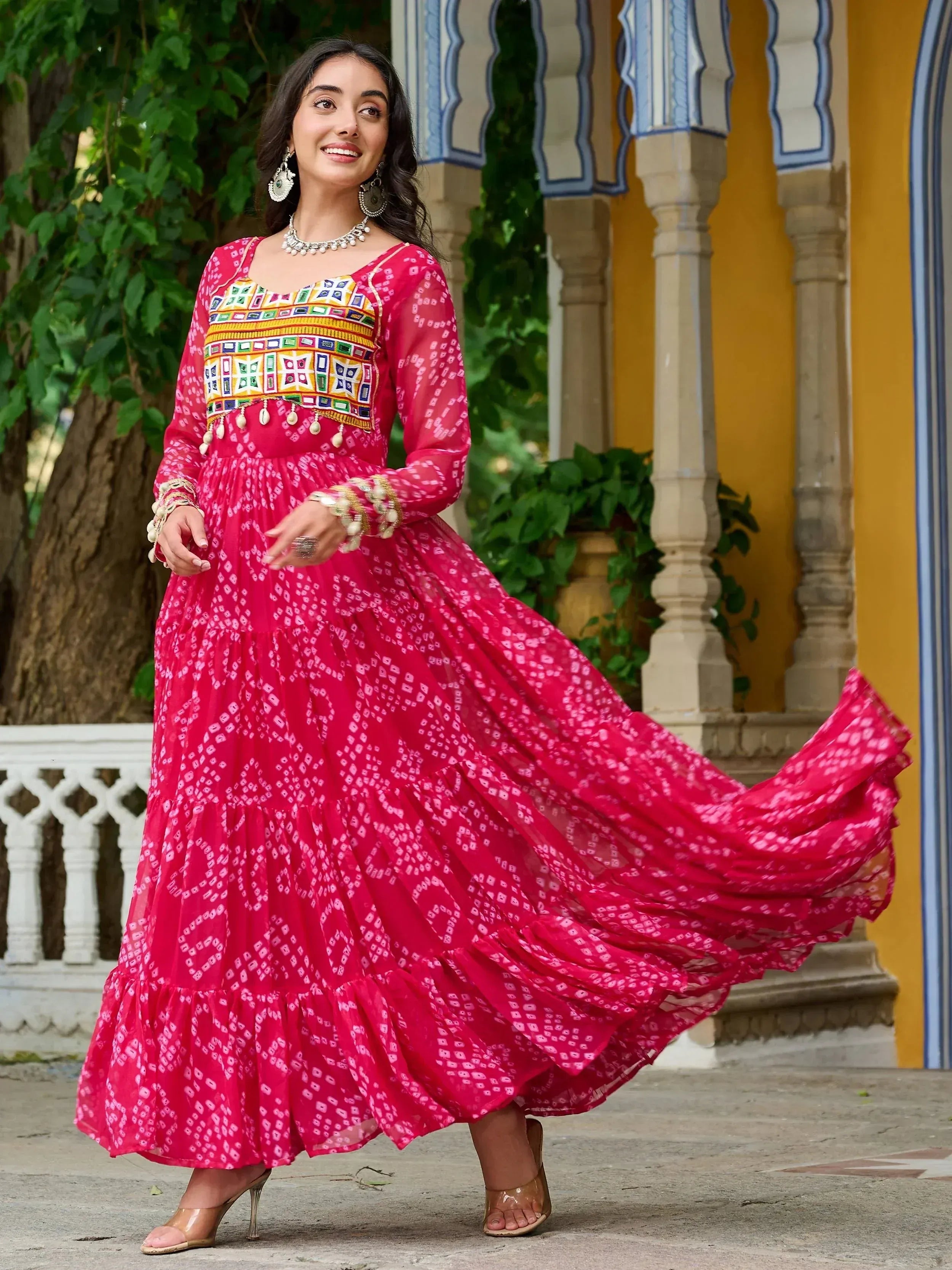 Vibrant pink ethnic gown with colorful embroidery, perfect for Indian celebrations and festive occasions.