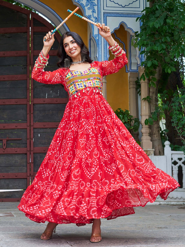 Woman in red ethnic gown with mirror work, dancing with dandiya sticks, traditional Indian wear