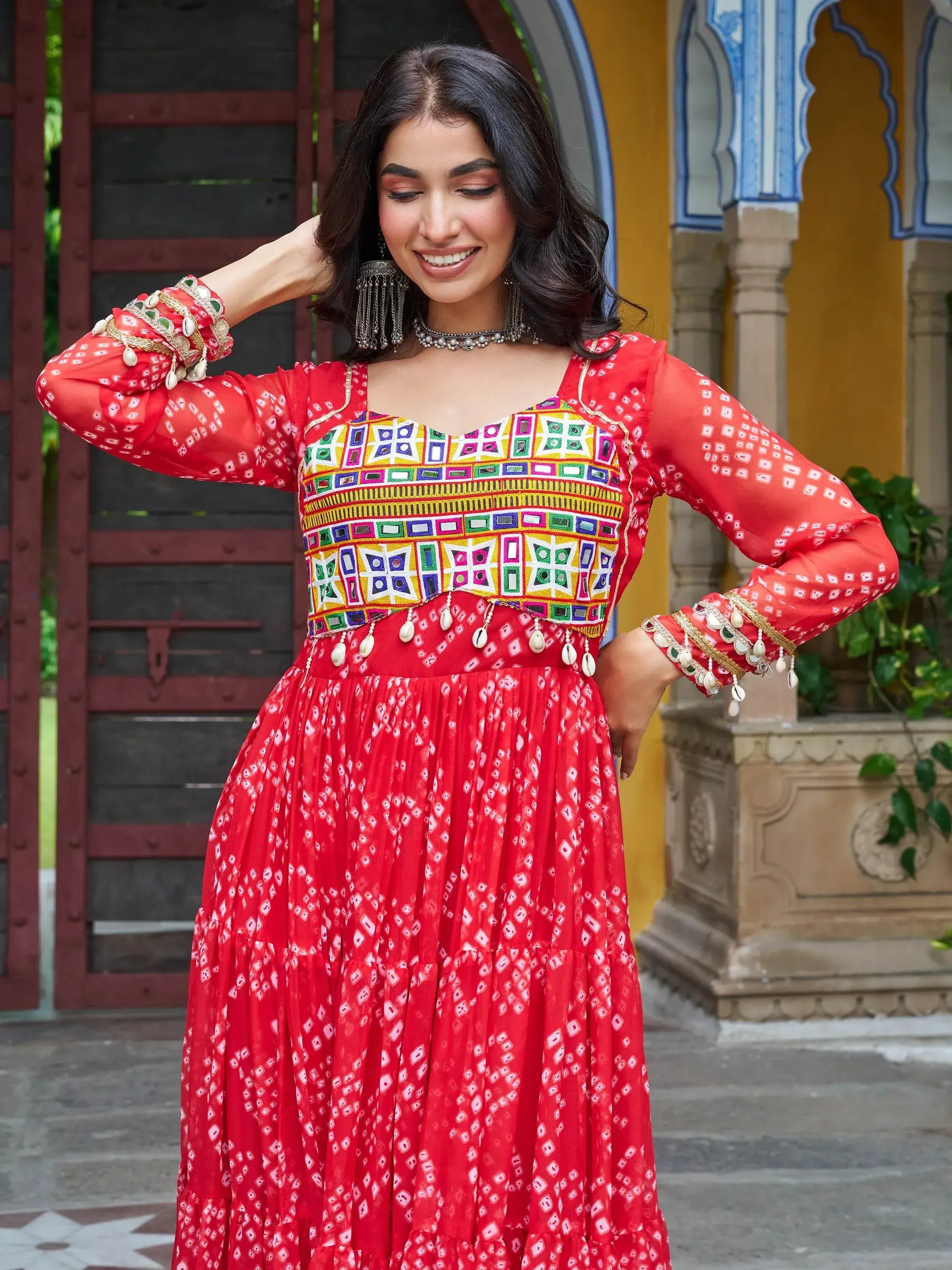 Red ethnic gown with mirror work and bandhani print, perfect for Indian festivals and celebrations.