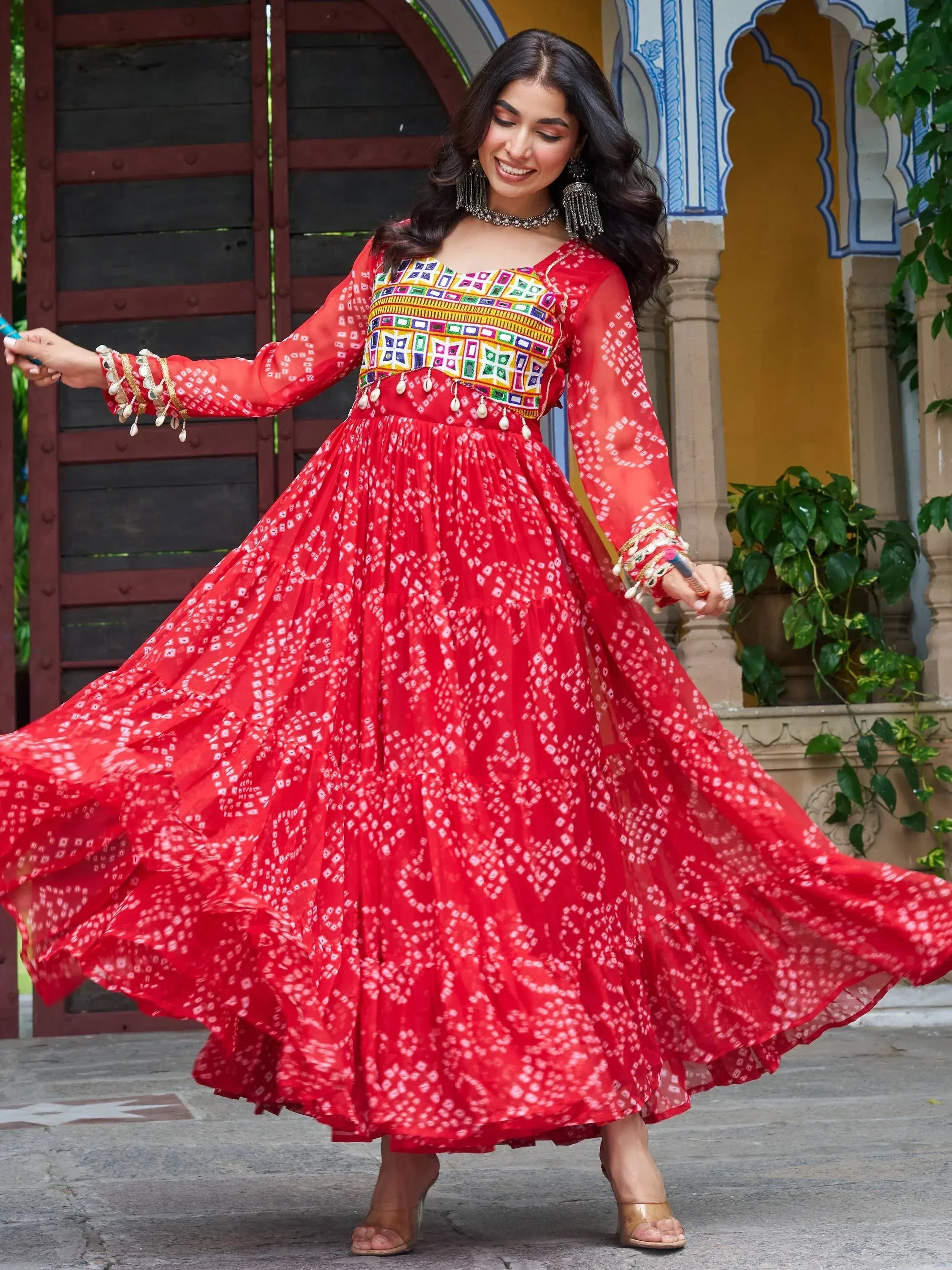 Red printed ethnic gown with colorful embroidery, perfect for Indian festive occasions and celebrations.