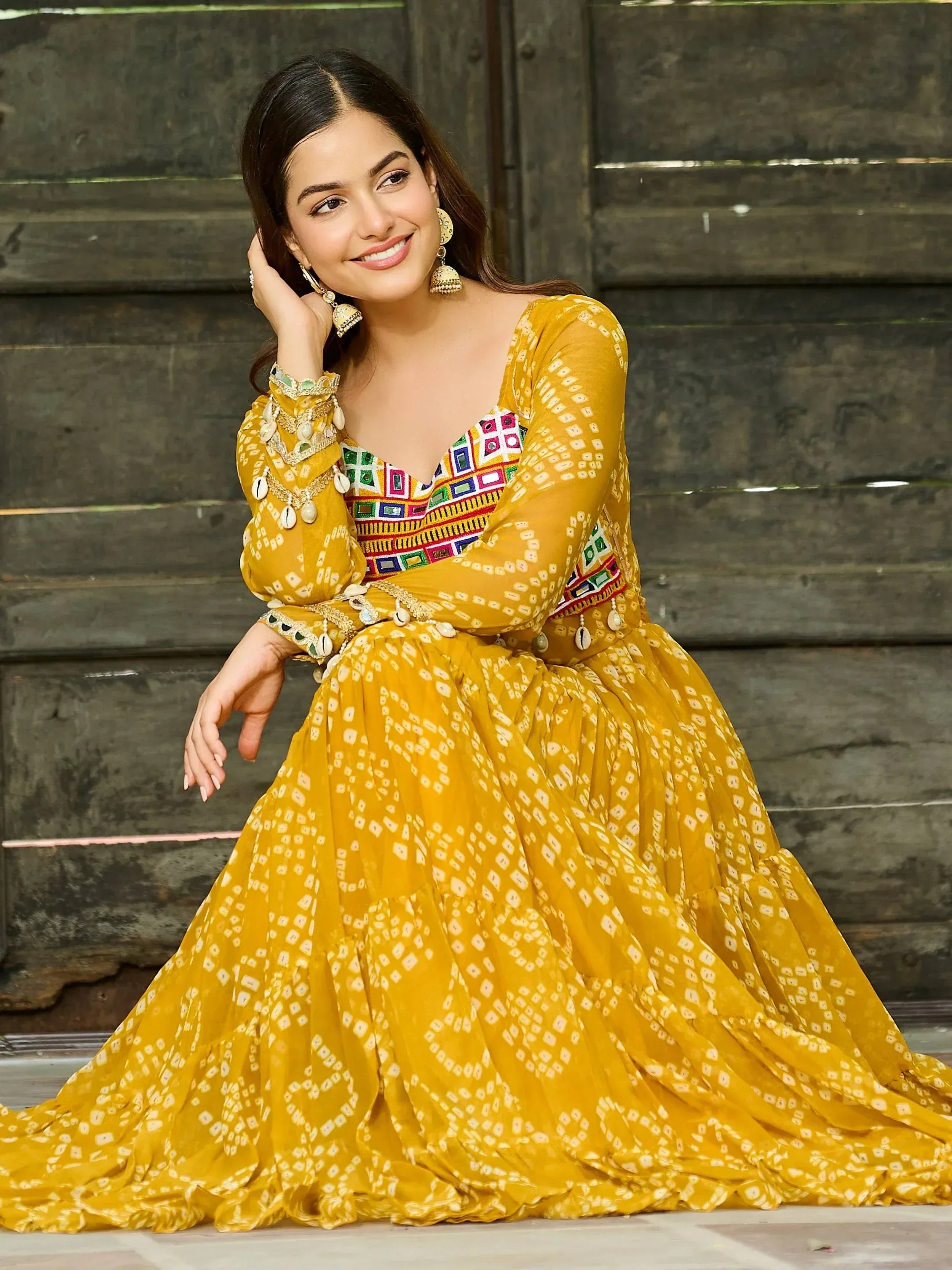 Yellow ethnic gown with mirror work and shell embellishments, perfect for Indian festive wear