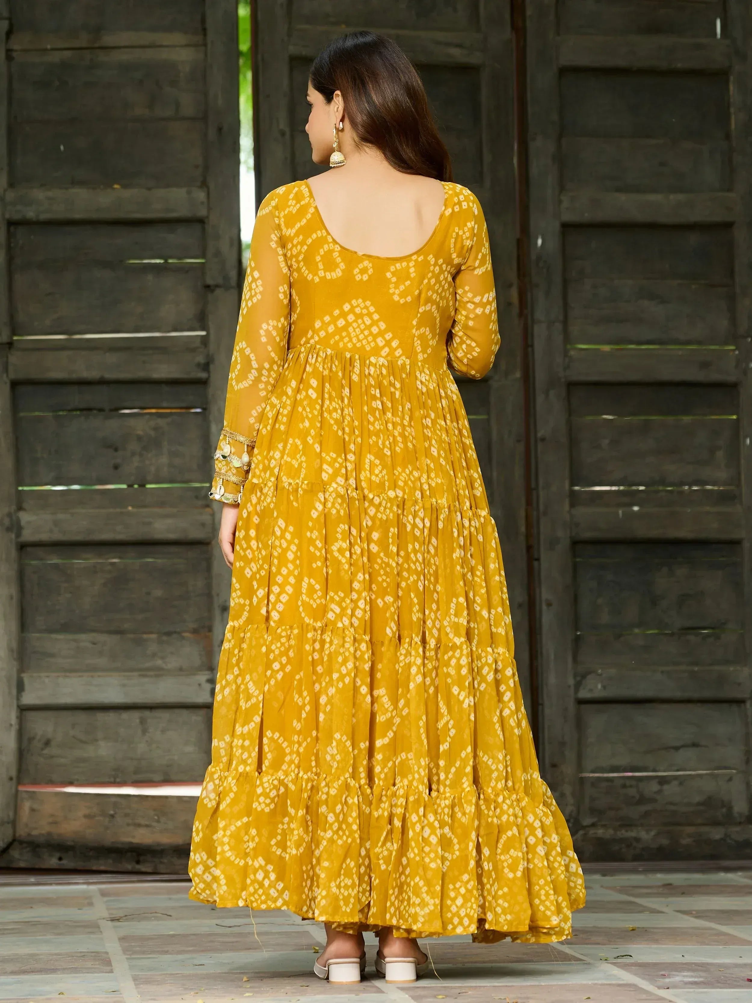 Mustard yellow ethnic gown with white block print, tiered skirt, and embellished sleeves for women