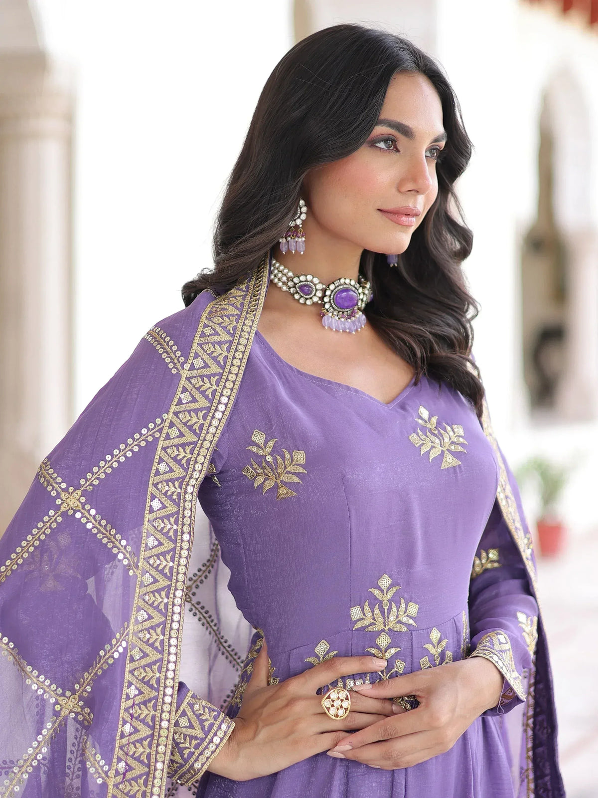 Purple embroidered ethnic gown with gold detailing and matching jewelry for festive occasions