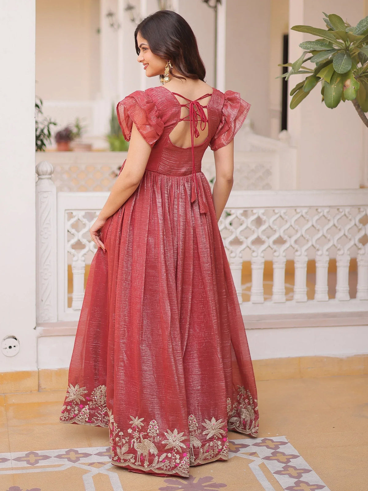 Woman in a red embroidered ethnic gown with puff sleeves and back tie detail