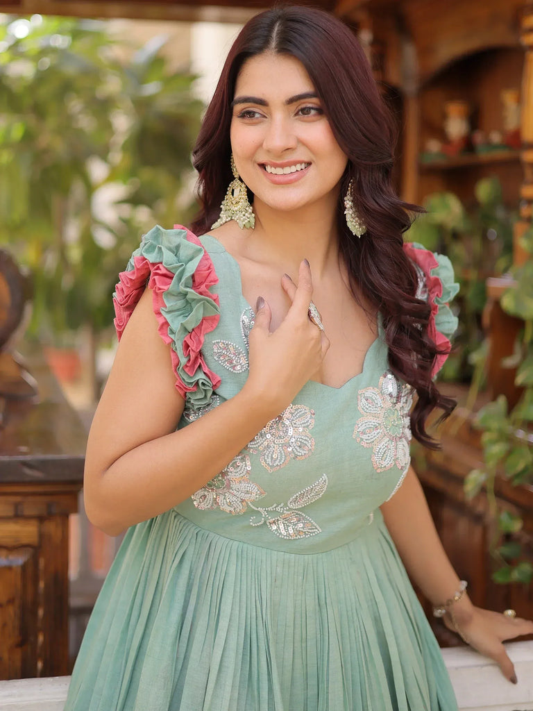 Mint green ethnic gown with floral sequin embroidery and ruffled sleeves, perfect for Indian occasions.