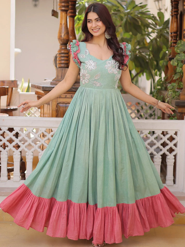 Mint green ethnic gown with pink ruffle hem and floral embroidery, perfect for Indian occasions.