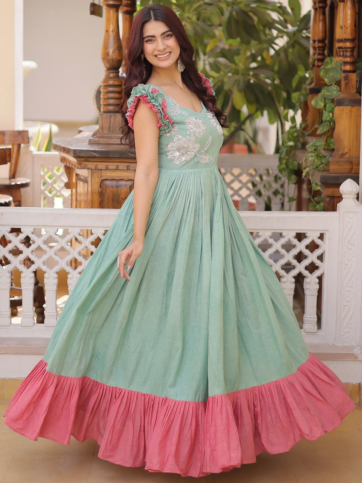 Mint green ethnic gown with pink ruffle hem and floral embroidery, perfect for Indian occasions