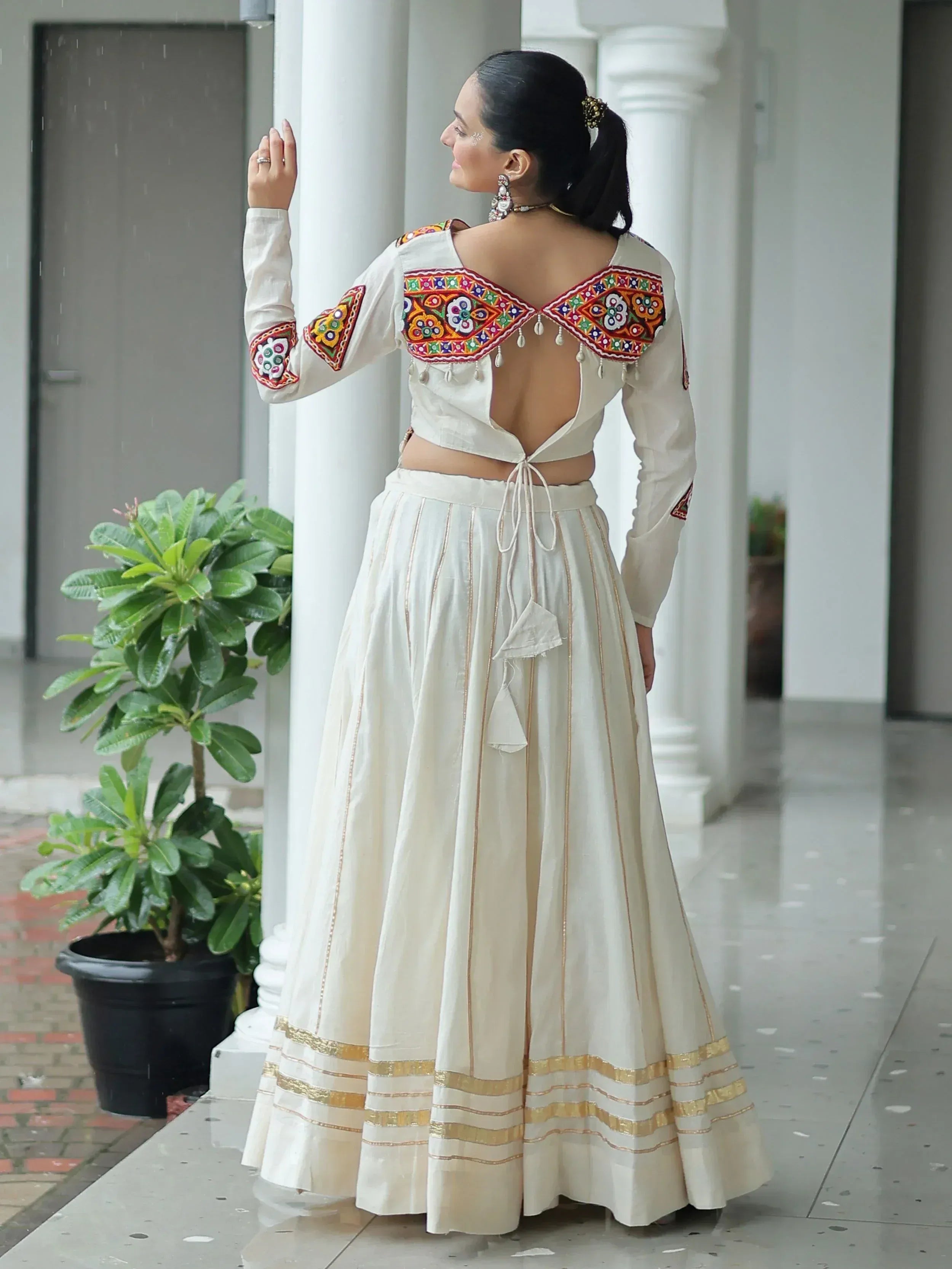White embroidered lehenga choli with backless blouse and gold trim, ideal for Indian ethnic wear