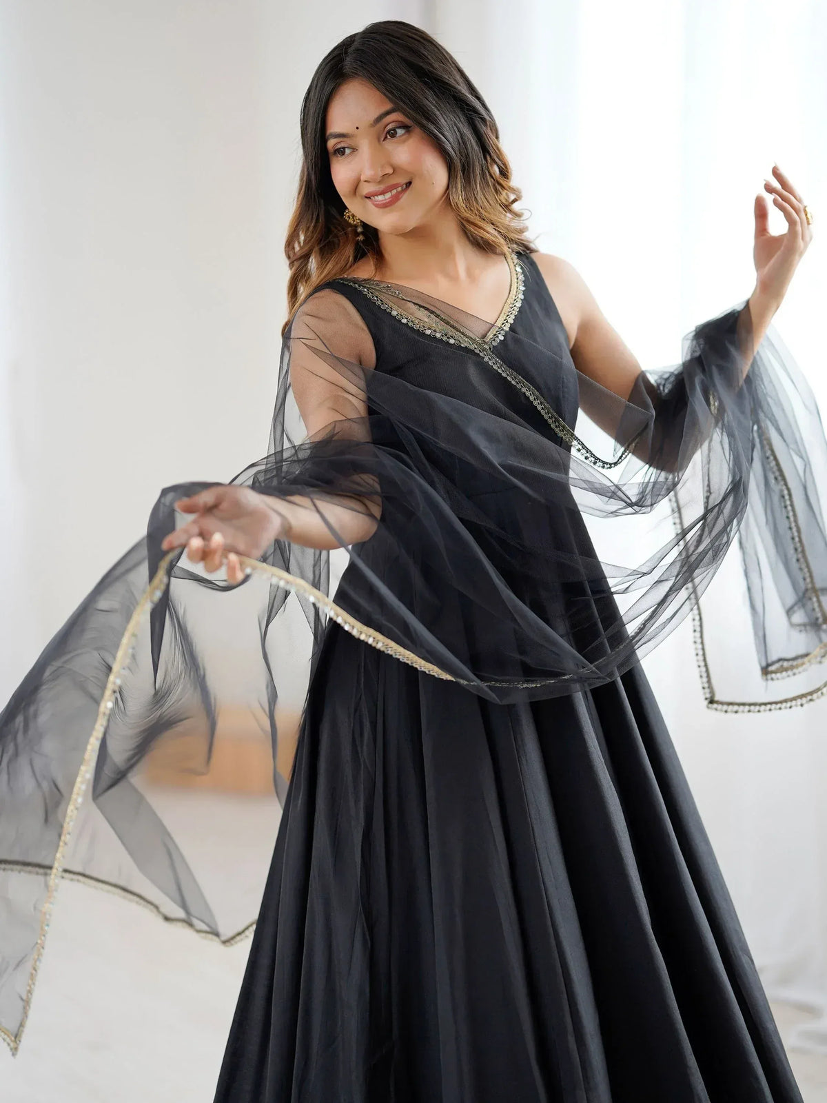Black ethnic gown with sheer cape and gold trim, perfect for Indian weddings or parties