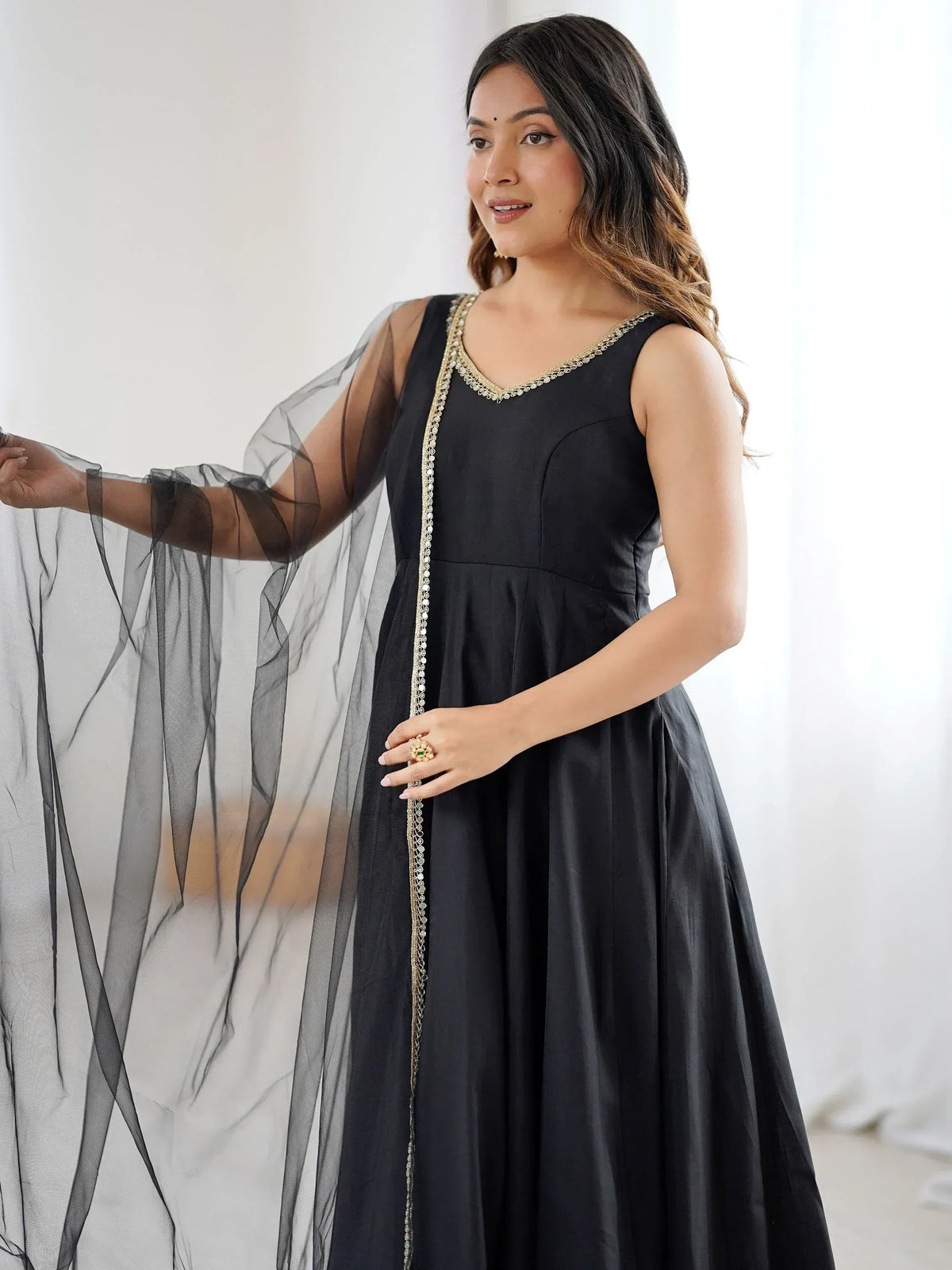 Black ethnic gown with gold embroidery and sheer overlay, perfect for Indian festive occasions.