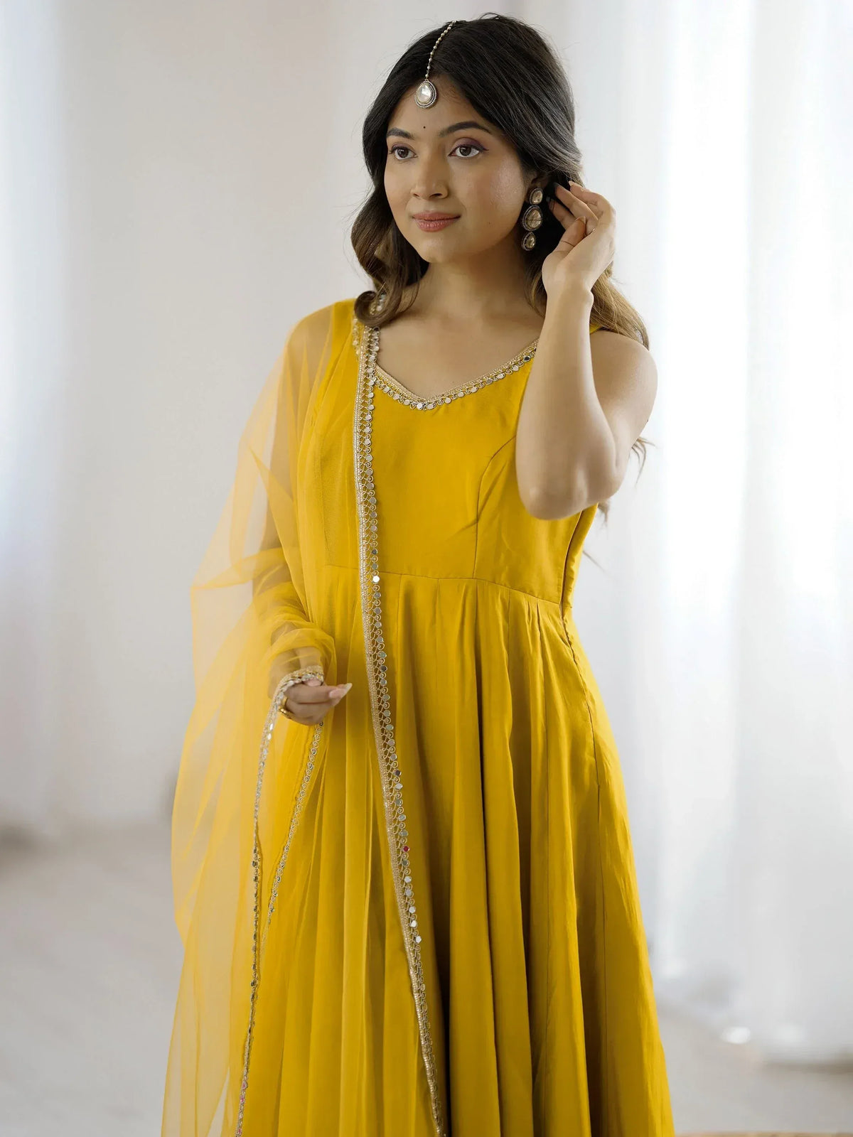 Yellow ethnic gown with gold embroidery and sheer dupatta, perfect for Indian festive wear