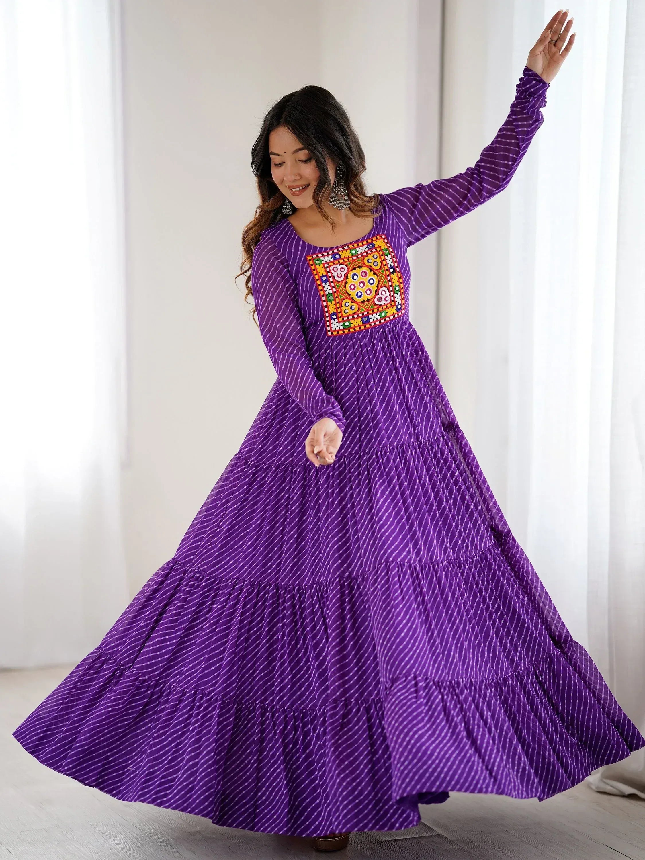 Purple ethnic gown with mirror work, long sleeves, tiered skirt, perfect for Indian occasions