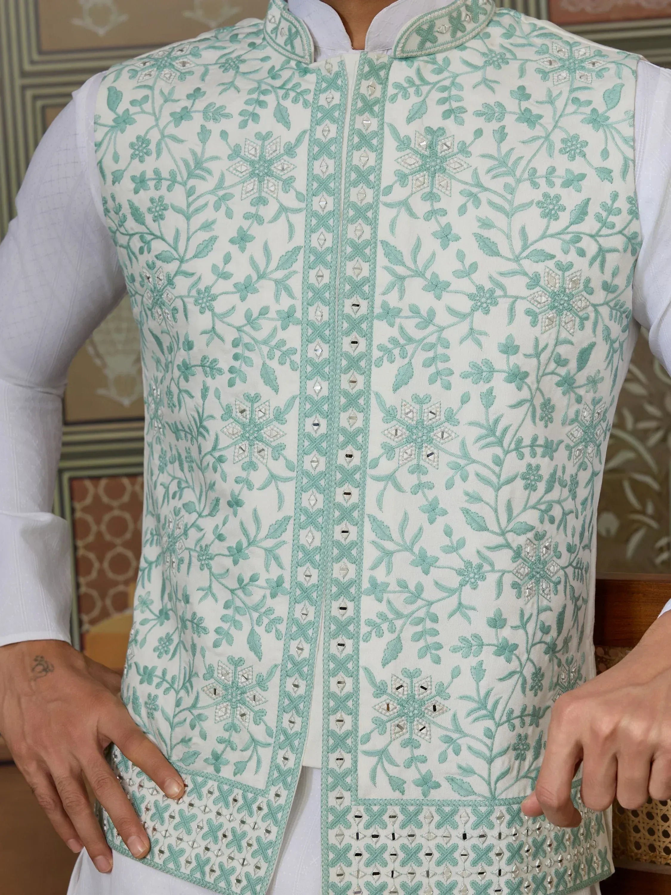 Mint green embroidered Nehru jacket with floral patterns and mirror work, paired with white kurta for ethnic wear.