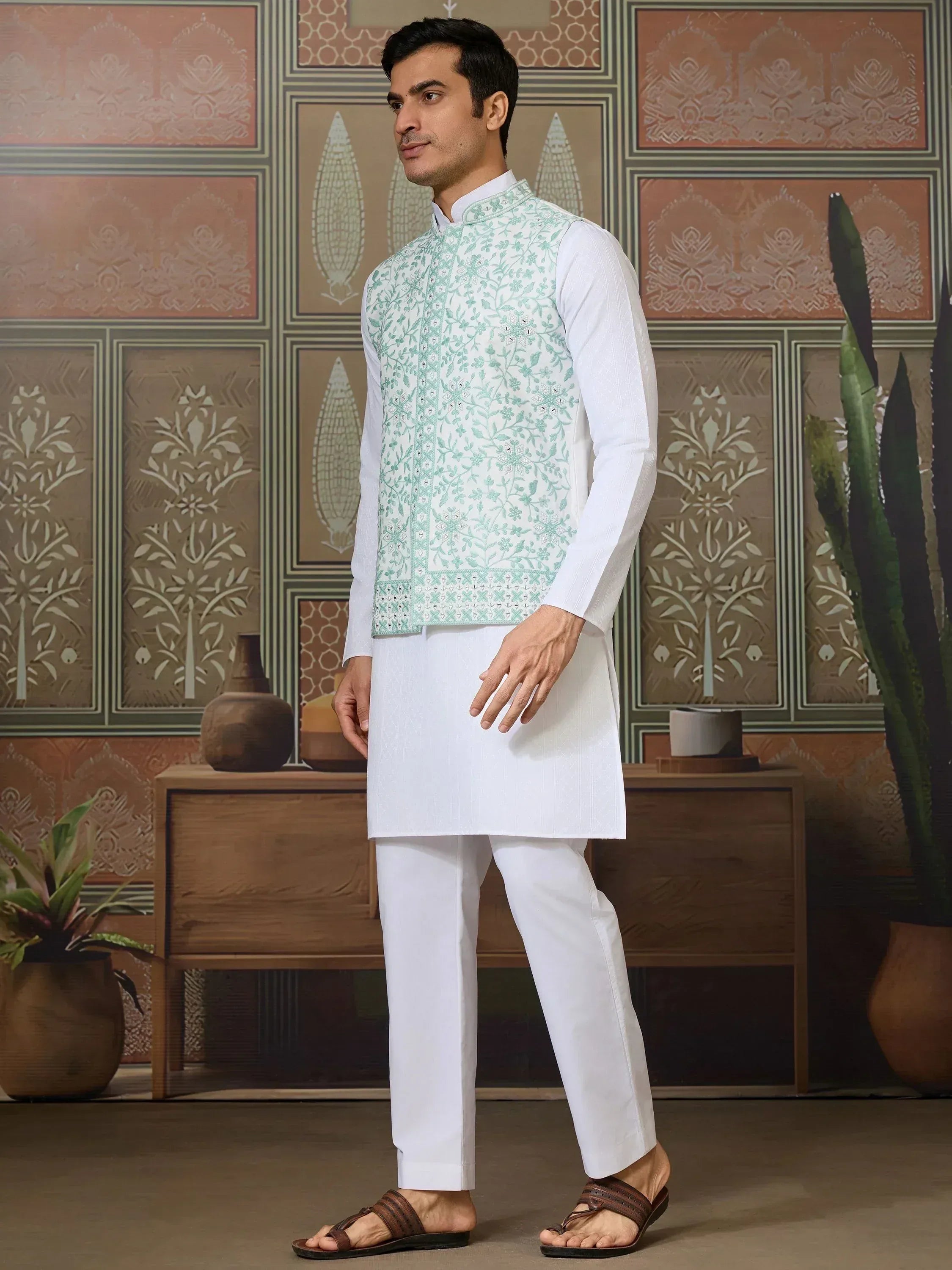 Man in white kurta pajama with mint green embroidered vest, ethnic Indian wear