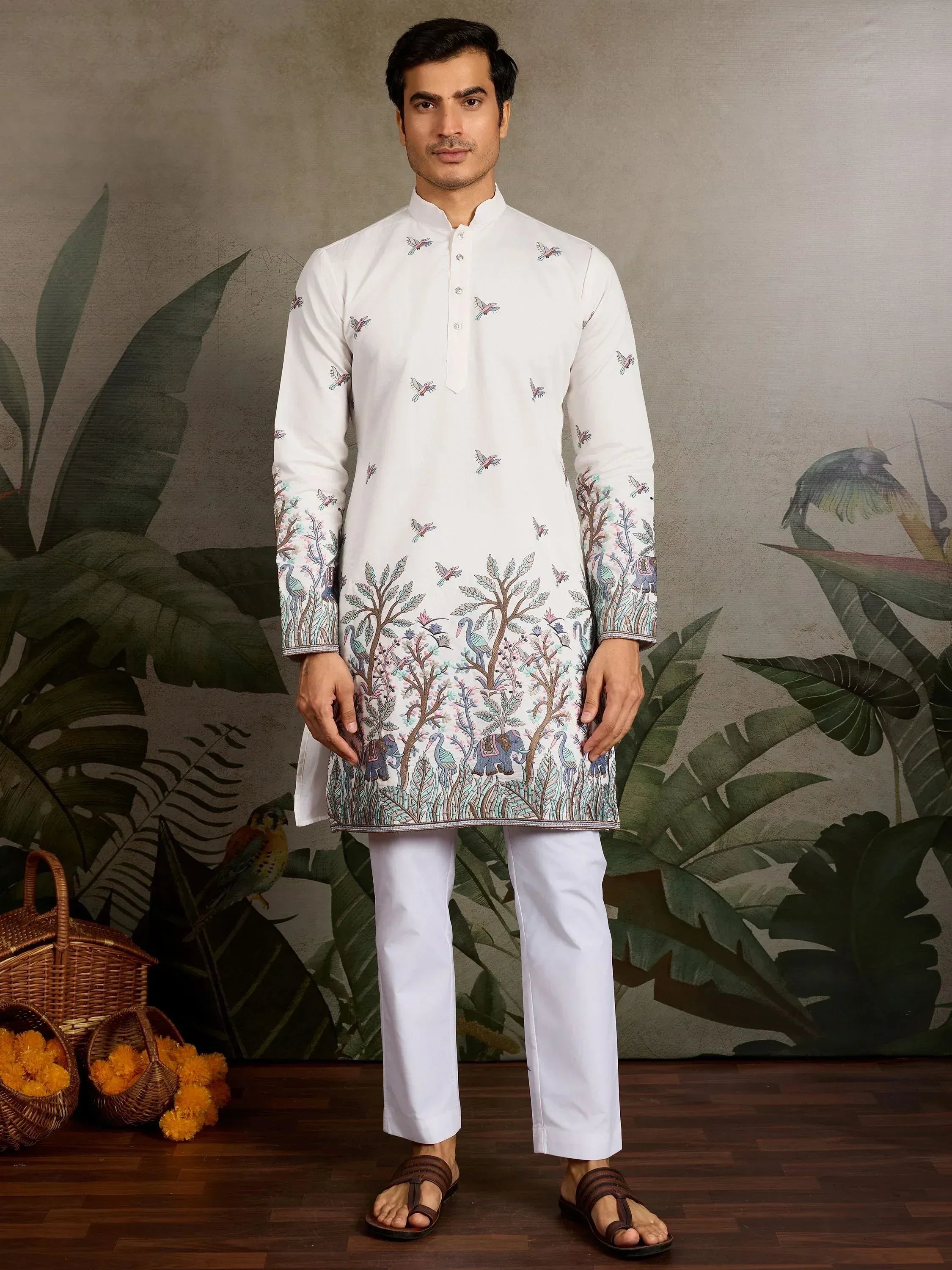 White embroidered kurta with bird and elephant motifs, paired with white pants for ethnic wear