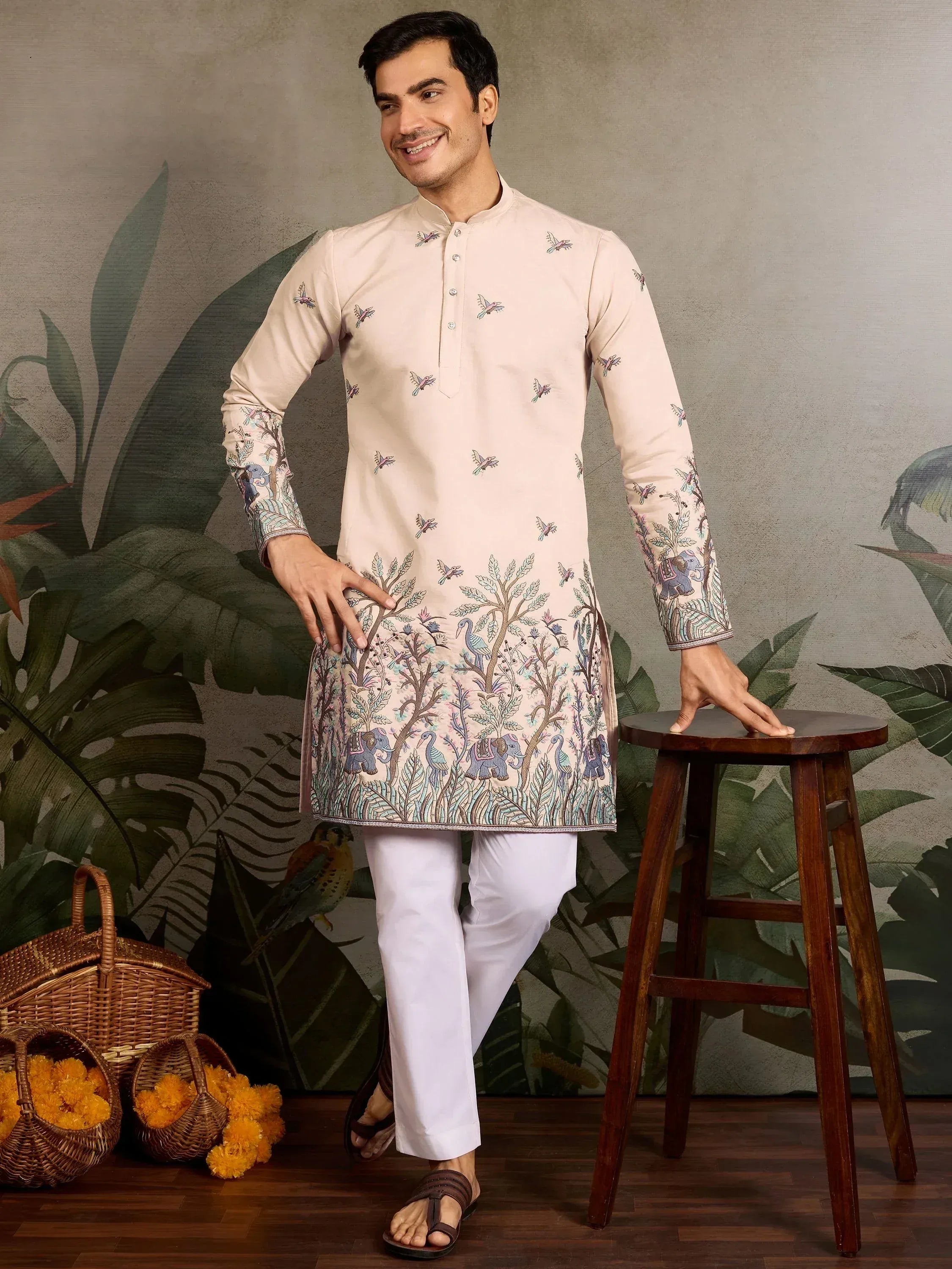 Men's embroidered kurta with elephant and bird motifs, paired with white pants for ethnic wear