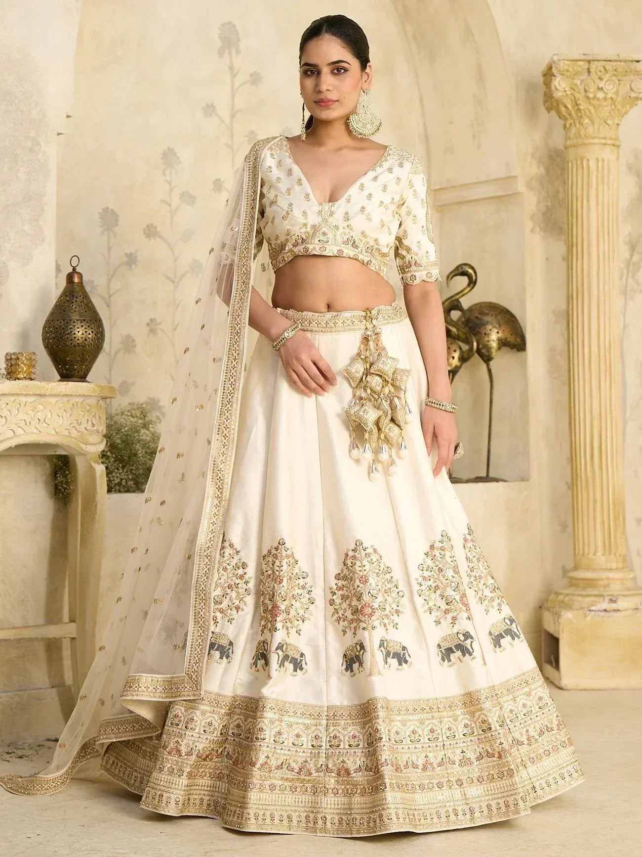 Elegant ivory lehenga choli with gold embroidery, elephant motifs, and matching dupatta for Indian weddings