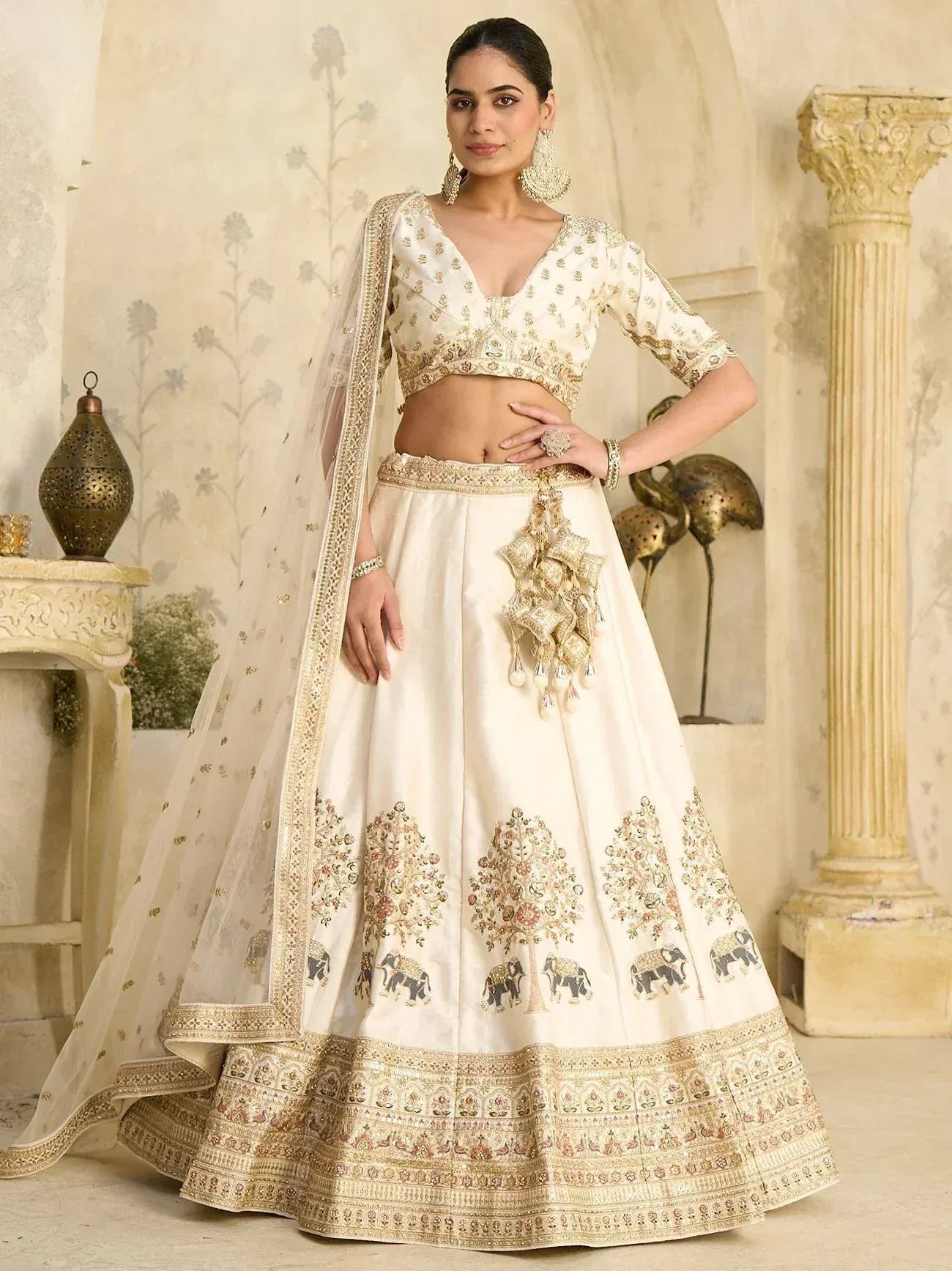 Cream embroidered lehenga choli with elephant motifs, gold detailing, and sheer dupatta for Indian ethnic wear