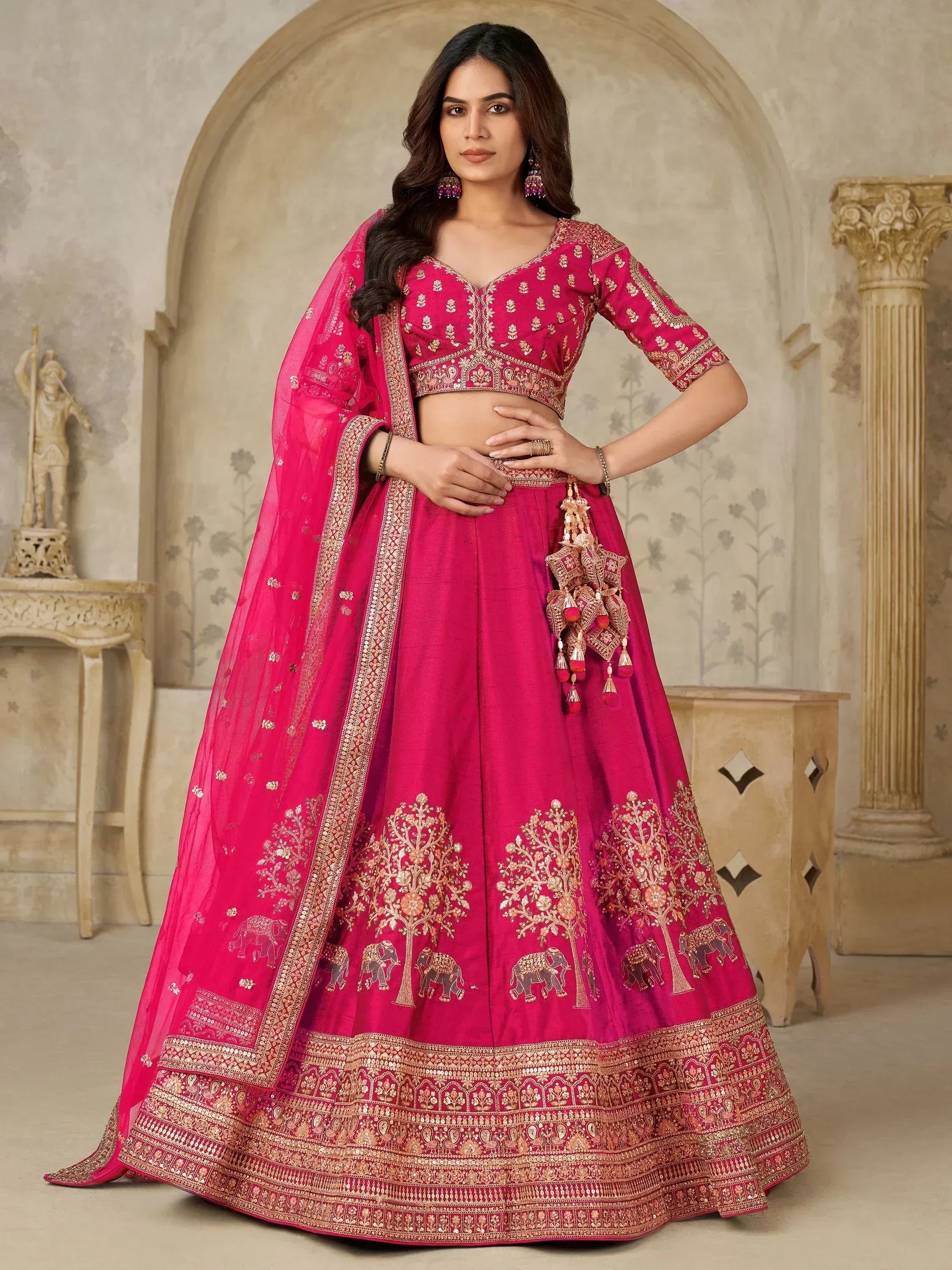 Fuchsia designer lehenga choli with gold embroidery, elephant motifs, and matching dupatta for Indian ethnic wear