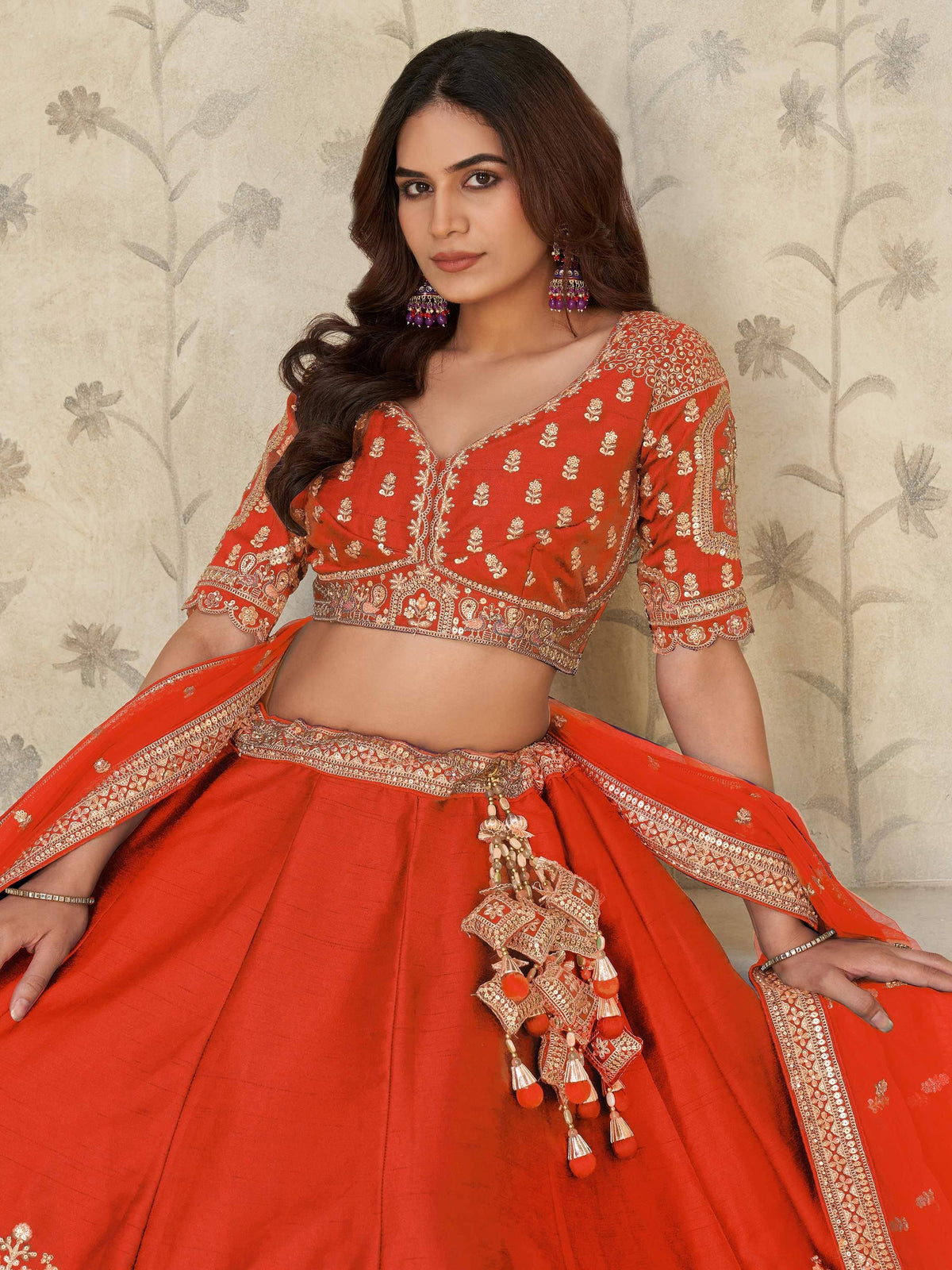 Red embroidered lehenga choli with gold detailing and tassels, Indian ethnic wear for women