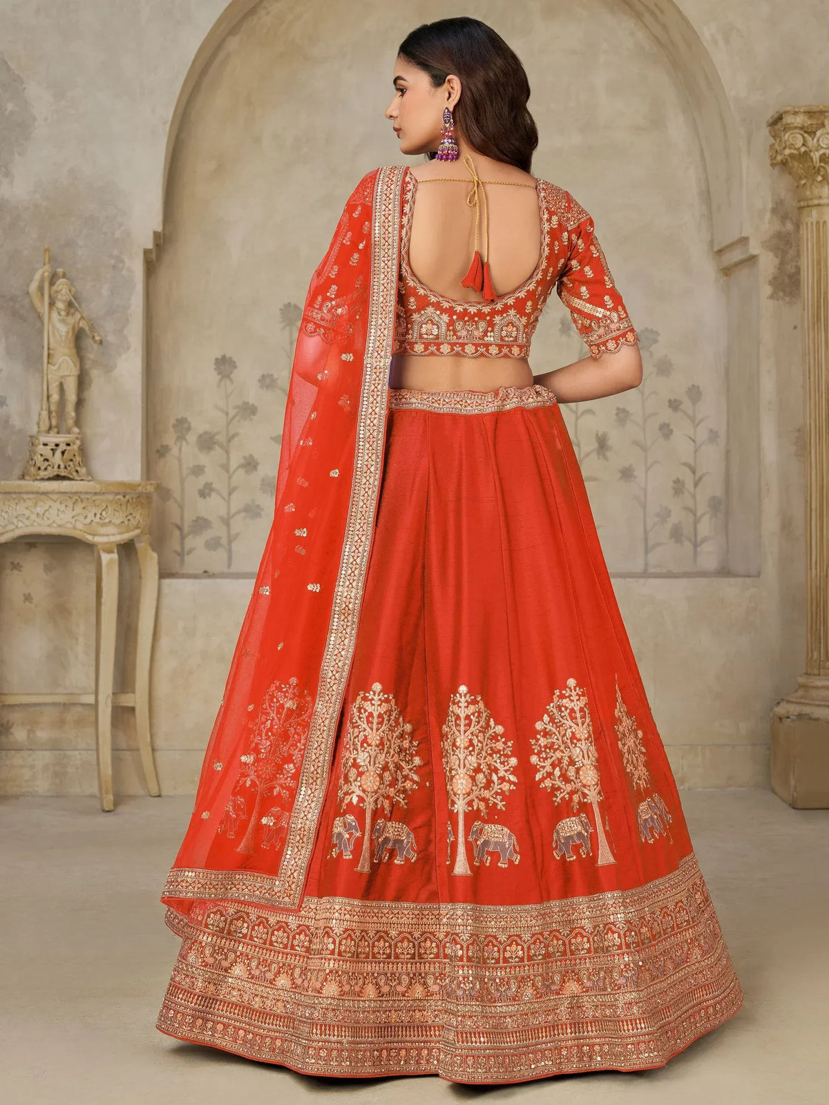 Red designer lehenga choli with gold embroidery, elephant motifs, and backless blouse for Indian ethnic wear