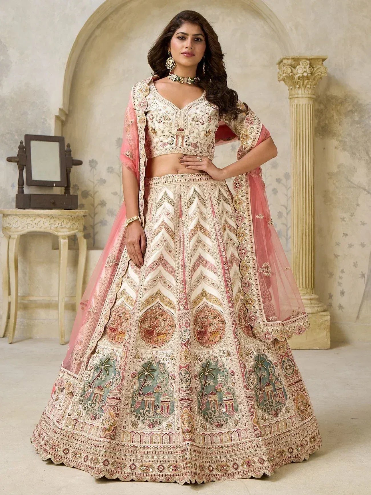 Elegant ivory and pink embroidered lehenga choli with intricate motifs and sheer dupatta, perfect for Indian weddings.