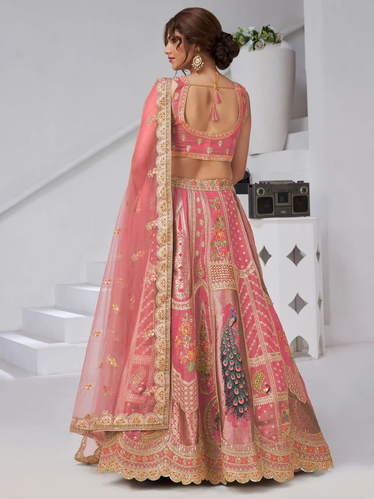 Pink embroidered lehenga choli with peacock motif, floral designs, and gold detailing for Indian ethnic wear